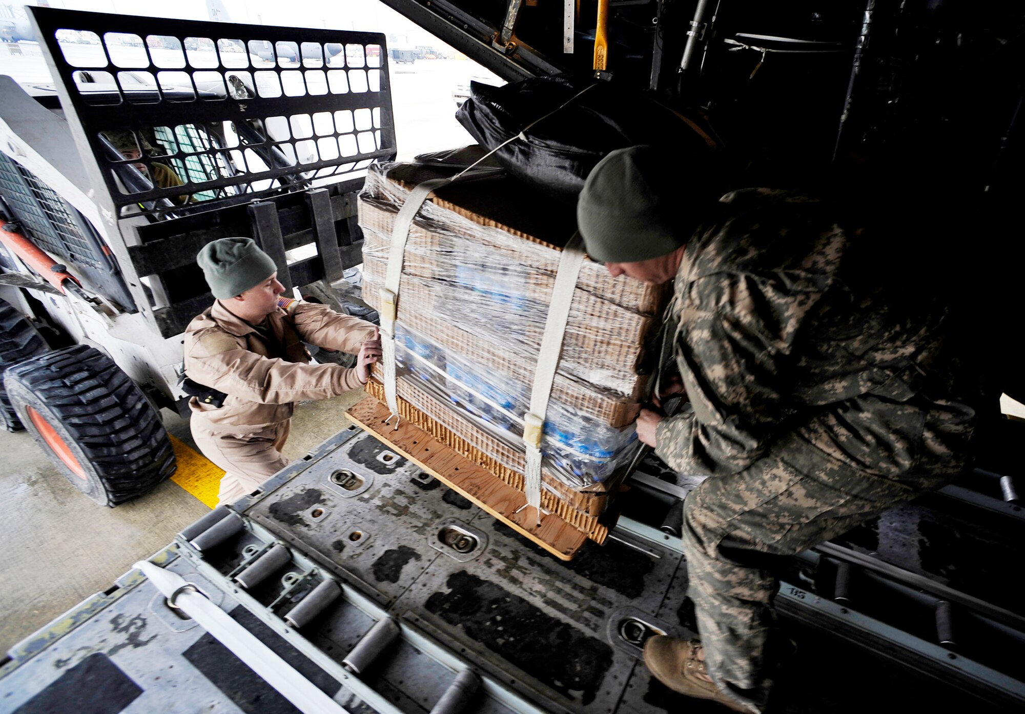 Master Sgt. Clay Holt helps Army Sgt. Matthew Davenport load a C-130 Hercules with low-cost, low-altitude resupply bundles Feb. 6, 2010, in Afghanistan. Sergeant Holt is a loadmaster with the 774th Expeditionary Airlift Squadron at Bagram Airfield, Afghanistan. Sergeant Davenport is an out-load NCO assigned to Combined Joint Special Operations Task Force Afghanistan. (U.S. Air Force photo/Staff Sgt. Angelita Lawrence)
