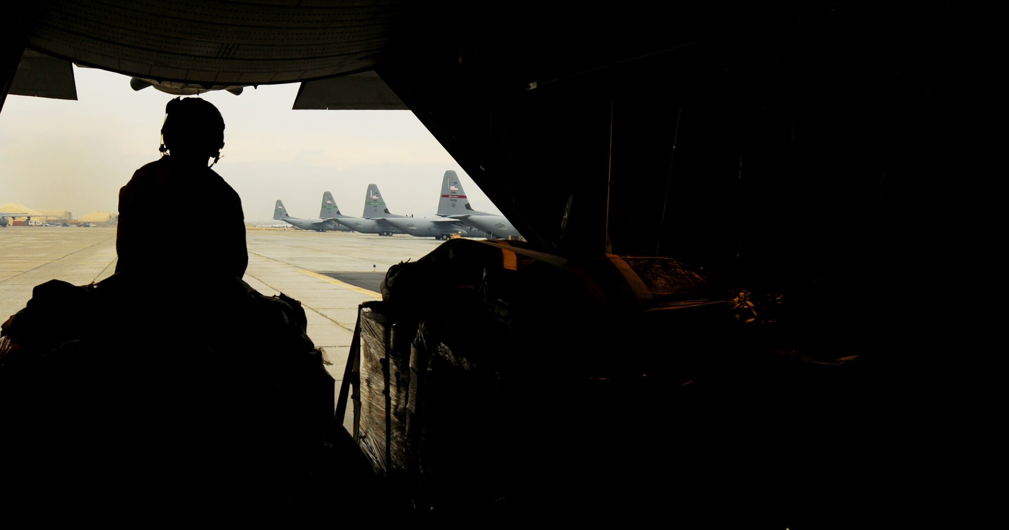 Airman 1st Class Kameron Trout watches as a C-130 Hercules prepares to take off before airdropping low-cost, low-altitude resupply bundles Feb. 6, 2010, in Afghanistan. Airman Trout is a loadmaster with the 774th Expeditionary Airlift Squadron at Bagram Airfield, Afghanistan. (U.S. Air Force photo/Staff Sgt. Angelita Lawrence)