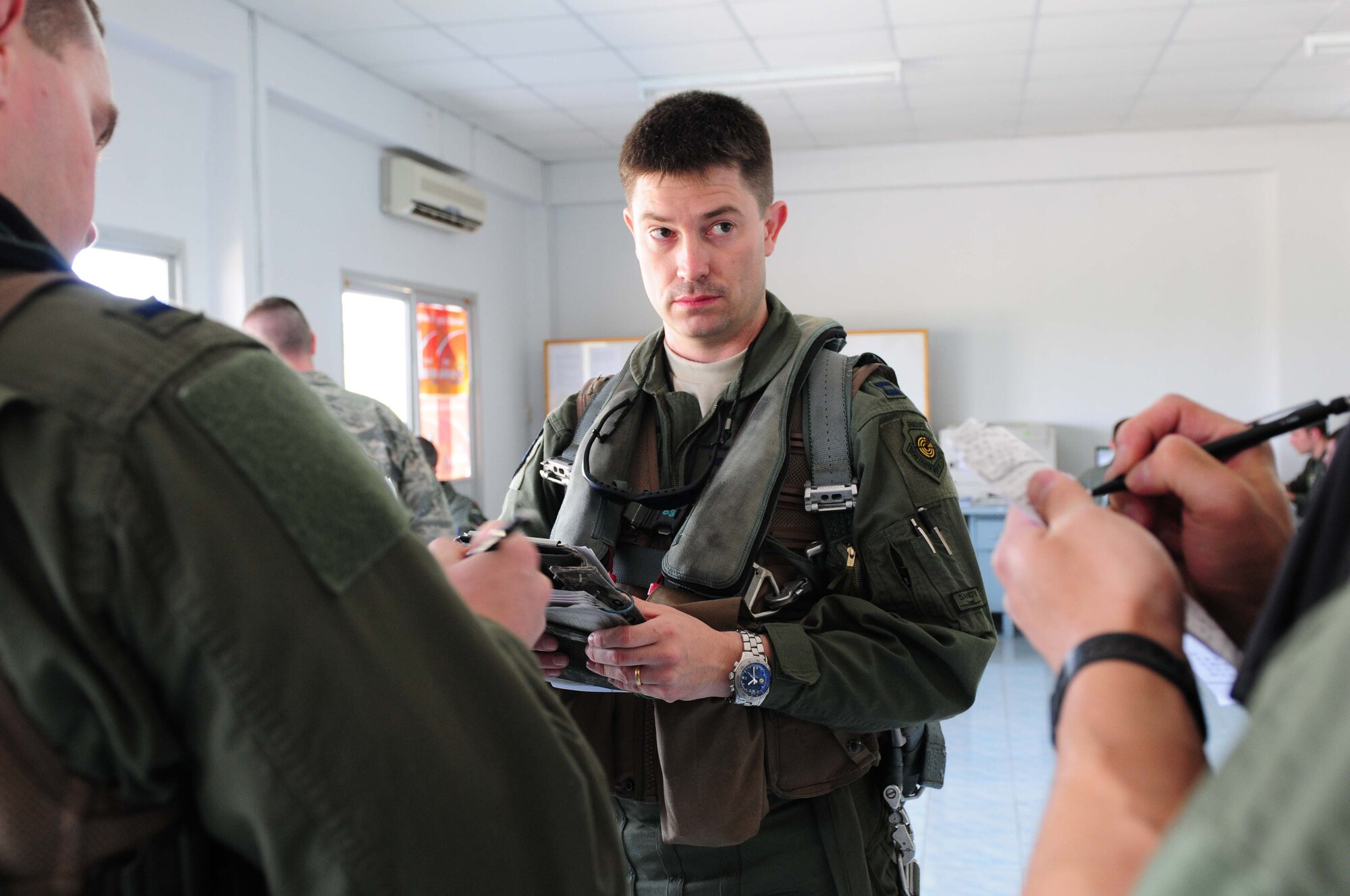 Capt. James Hunt reviews flight information with his fellow A-10 Thunderbolt II pilots prior to embarking on a four-ship training mission at Udon Thani Royal Thai Air Force Base, Thailand, March 4. Captain Hunt is deployed to the exercise from the 25th Fighter Squadron at Osan Air Base, South Korea.  His squadron is participating in the annual, multilateral field training exercise involving the U.S. Air Force, Royal Thai Air Force and Army, and the Republic of Singapore Air Force March 1-12.  (U.S. Air Force photo/Capt. Genieve David)