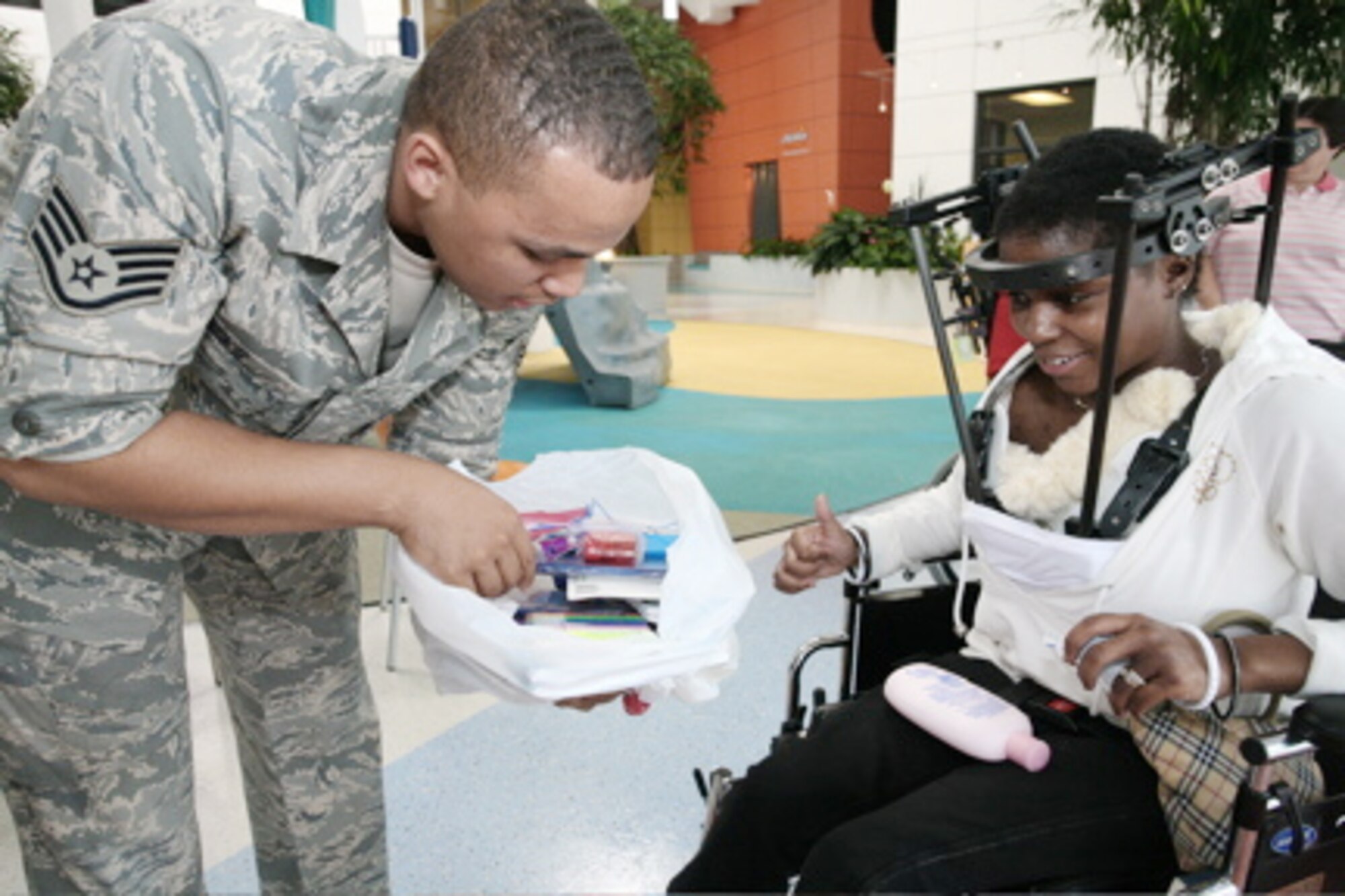 Staff Sgt. Jewell Hicks hands toys to a child at a medical facility as part of Airmen for Children. Sergeant Hicks is currently an imagery analyst at the 13th Intelligence Squadron at Beale Air Force Base, Calif. (Courtesy photo)
