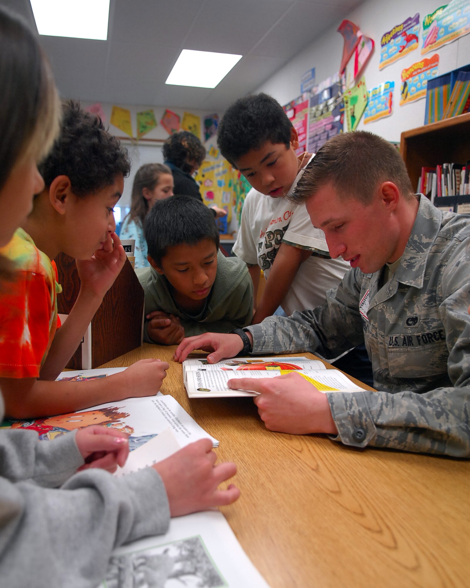 Airman 1st Class Christopher McDowell, from the 9th Communication Squadron, reads a book as children listen attentively at Arboga Elementary School Mar. 2. Airman McDowell interacted with school children as part of Read across America, a nationwide reading event sponsored by the National Education Association. (U.S. Air Force photo/ Senior Airman Kevin Iinuma)