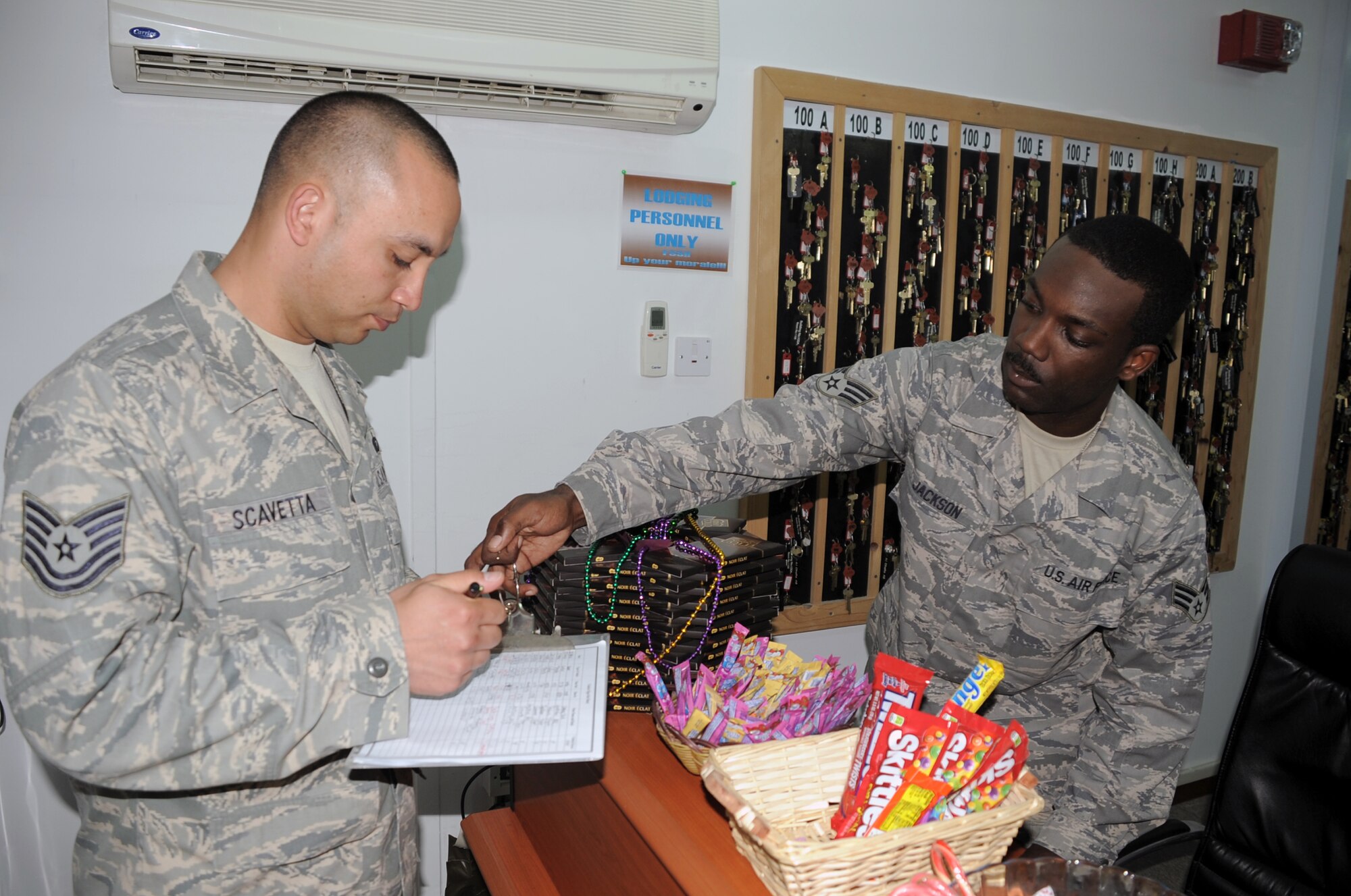 Senior Airman Robert Q. Jackson (right) helps a customer, Tech. Sgt. John Scavetta, at the 380th Expeditionary Force Support Squadron lodging facility at a non-disclosed base in Southwest Asia. Airman Jackson serves as the front desk manager for the facility. He is deployed from the 127th Force Support Squadron at Selfridge Air National Guard Base, Mich., and his hometown is Detroit, Mich. The 380th EFSS is a part of the 380th Air Expeditionary Wing which supports operations Iraqi Freedom and Enduring Freedom and the Combined Joint Task Force-Horn of Africa. (U.S. Air Force Photo/Master Sgt. Scott T. Sturkol/Released)