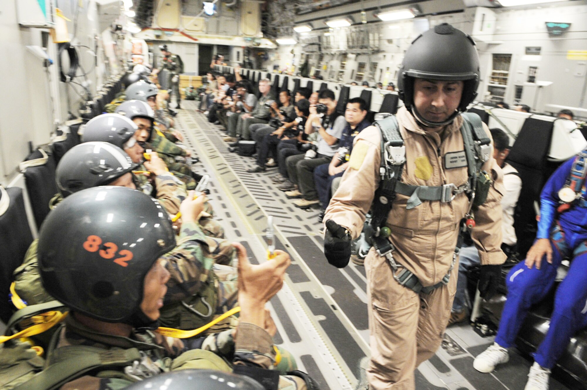Master Sgt. John Gaonagives the "thumbs up" to members of the Royal Thai Air Force parachute team as they ready for their first static-line jump from a C-17 Globemaster III March 3, 2010 at Dom Muang Royal Thai Air Force Base, Thailand. Sergeant Gaonagives is deployed to Cope Tiger 2010 from Pope Air Force Base, N.C. (U.S. Air Force photo/Tech. Sgt. Cohen A. Young)
