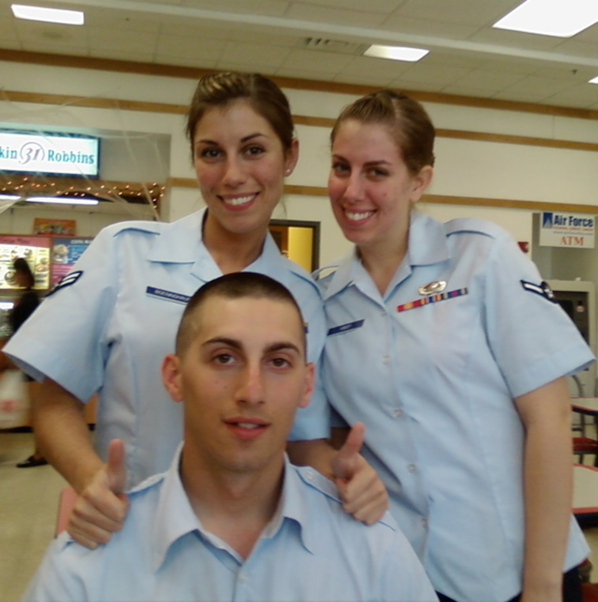 A photo taken during Airman 1st Class Jason Boeninghaus' graduation from basic training, he poses with his two sisters (from left) Senior Airman Corynn Silva and Airman 1st Class Laura Vidot. These siblings have come together at Dover Air Force base, and are a very tight knit family. (U.S Air Force photo/Courtesy photo)