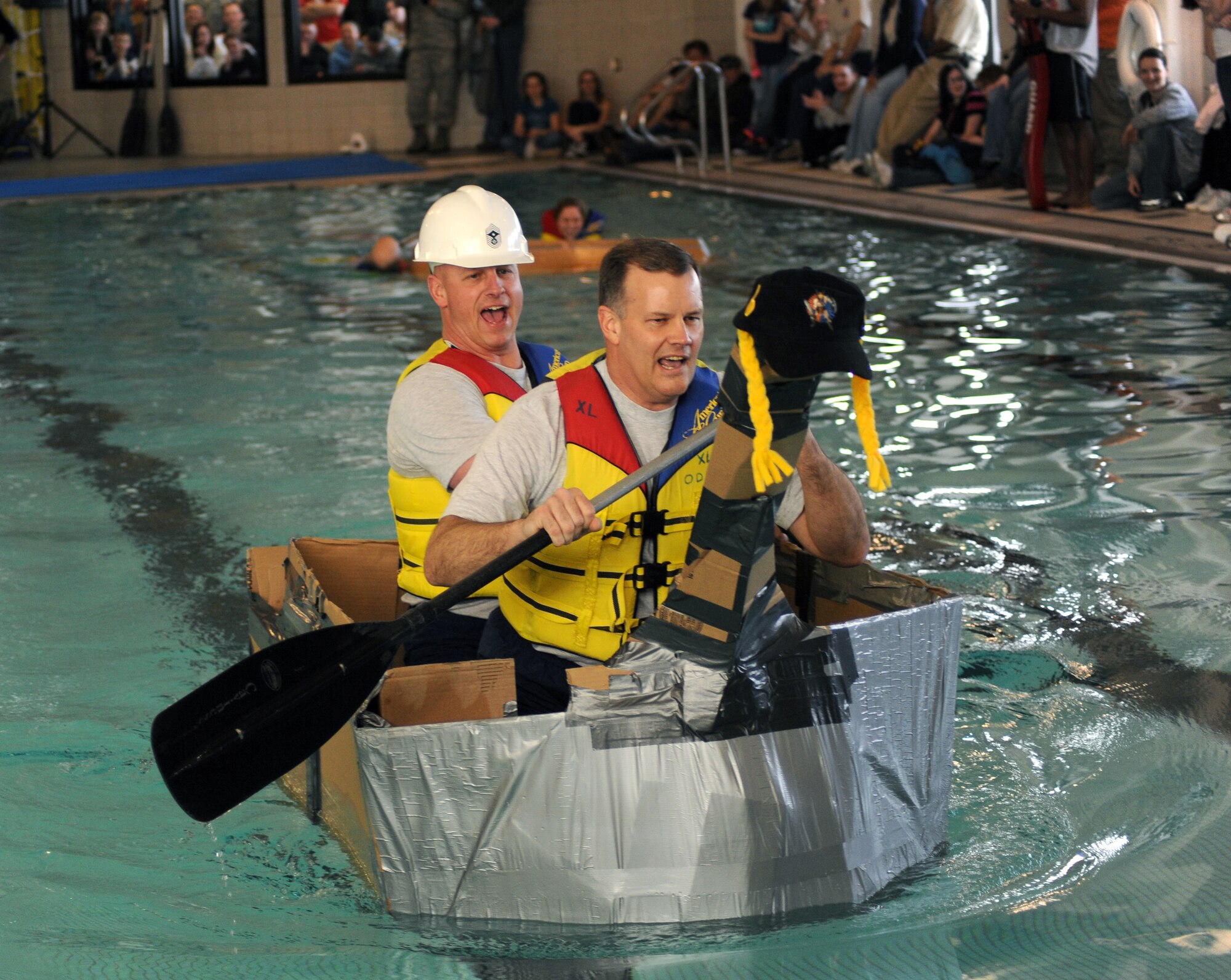 Col. Don Shaffer, 319th Air Refueling Wing commander, and Chief Master Sgt. Scott A. Fuller, 319th ARW command chief, paddle across the base’s pool during a boat race Feb. 25 at the fitness center on Grand Forks Air Force Base, N.D. The boat race is the highlight event of the 319th Air Refueling Wing’s Winter Bash, which was created to increase esprit-de-corps and allow Airmen to take a break from their day to day work environments. The wing also holds a Summer Bash in August. (U.S. Air Force photo by Tech. Sgt. Johnny Saldivar)