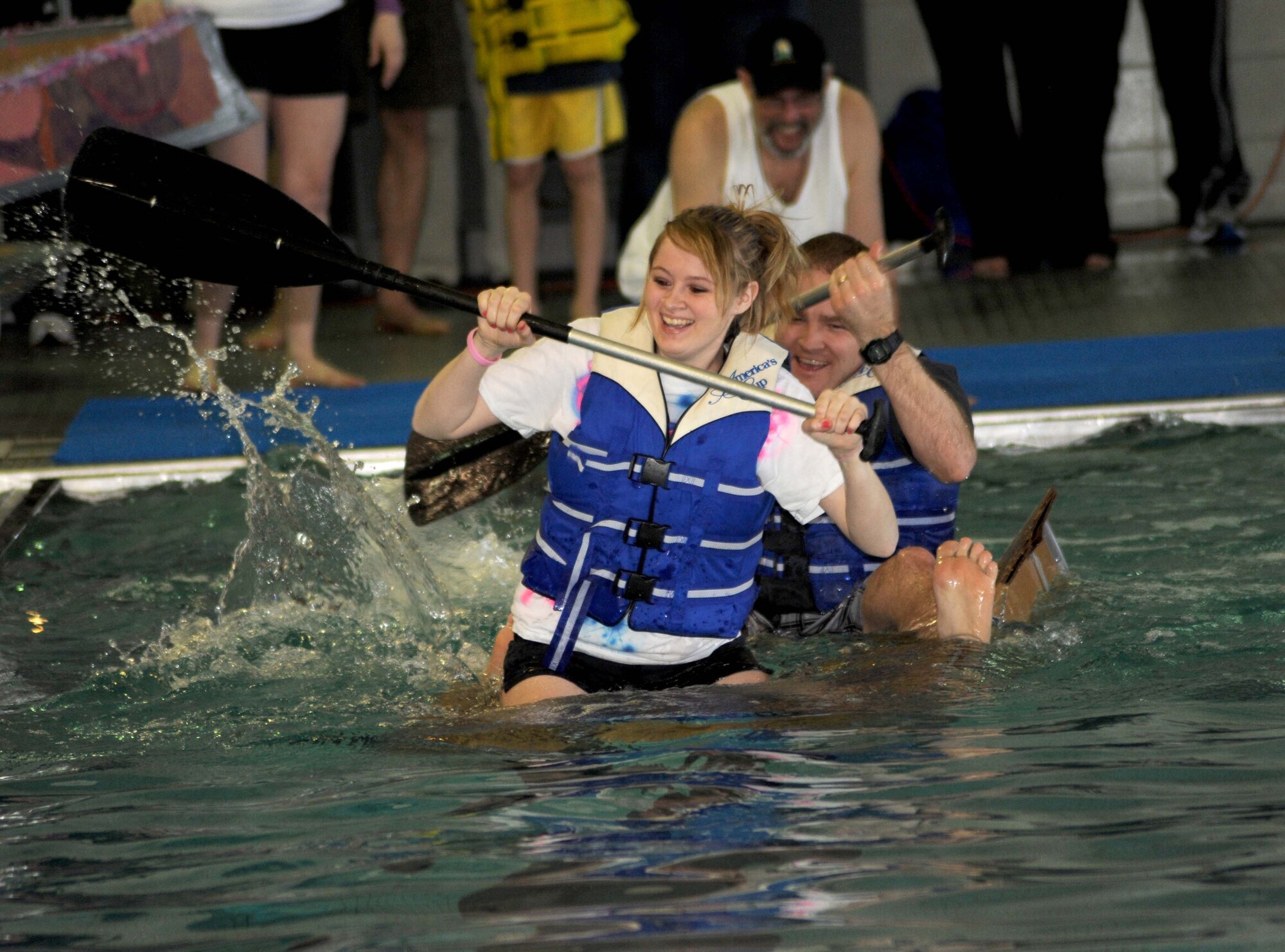 Tech. Sgt. Reed Honsey, 319th Communications Squadron, and his daughter, Jordan, paddle across the base’s pool during a boat race Feb. 25 at the fitness center on Grand Forks Air Force Base, N.D. The boat race is the highlight event of the 319th Air Refueling Wing’s Winter Bash, which was created to increase esprit-de-corps and allow Airmen to take a break from their day to day work environments. The wing also holds a Summer Bash in August. (U.S. Air Force photo by Tech. Sgt. Johnny Saldivar)
