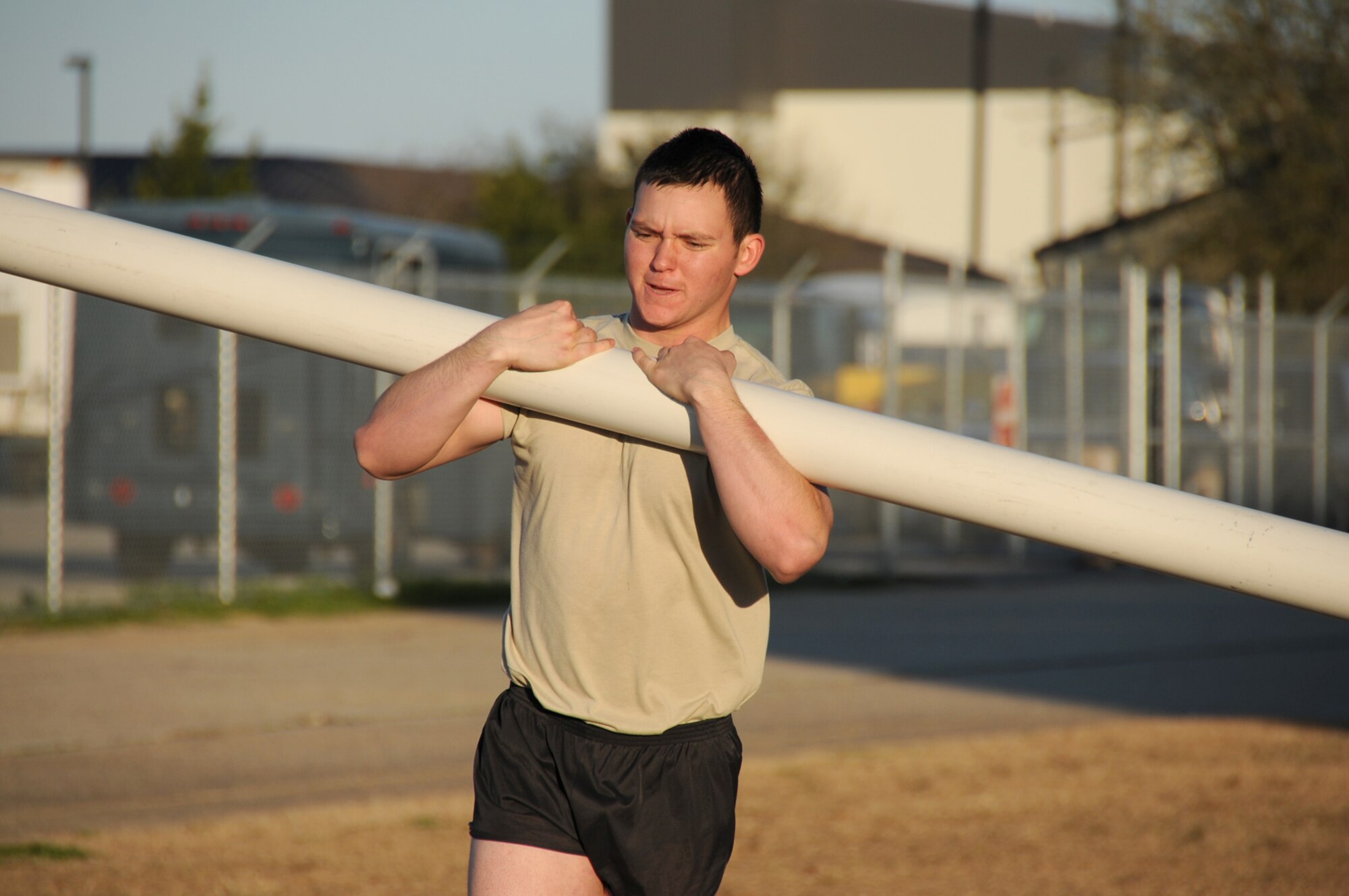 Airman Taylor Riggan, a combat weather student, carries a sloshpipe to a group of students during physical training outside of Matero Hall Feb. 25.  (U.S. Air Force photo by Kemberly Groue)