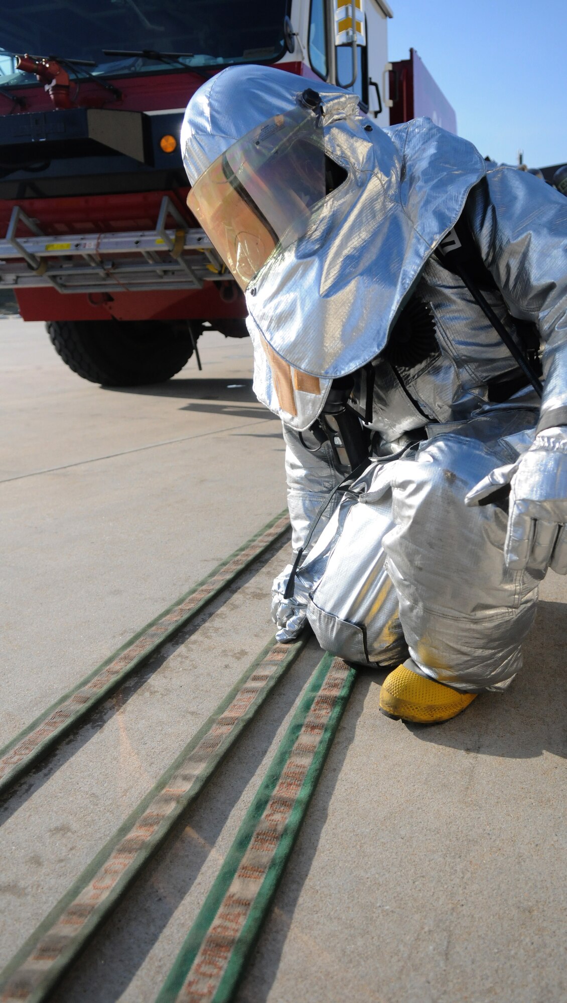 SPANGDAHLEM AIR BASE, Germany – A 52nd Civil Engineer Squadron firefighter pulls in the fire hose after responding to a simulated fire during Operation Saber Crown 10-04 March 3. The Phase II exercise evaluated the wing’s self-aid and buddy care execution, emergency response and chemical, biological, radiological, nuclear and explosive procedures to prepare for the upcoming NATO force evaluation. (U.S. Air Force photo/Airman 1st Class Staci Miller)