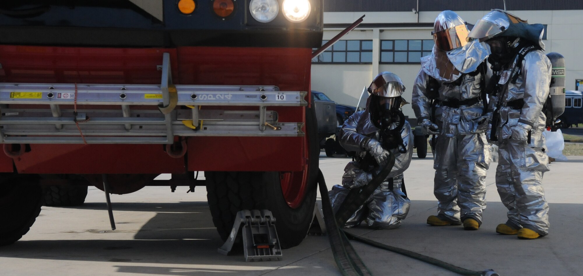 SPANGDAHLEM AIR BASE, Germany – 52nd Civil Engineer Squadron firefighters pull in the fire hose after responding to a simulated fire during Operation Saber Crown 10-04 March 3. The Phase II exercise evaluated the wing’s self-aid and buddy care execution, emergency response and chemical, biological, radiological, nuclear and explosive procedures to prepare for the upcoming NATO force evaluation. (U.S. Air Force photo/Airman 1st Class Staci Miller) 
