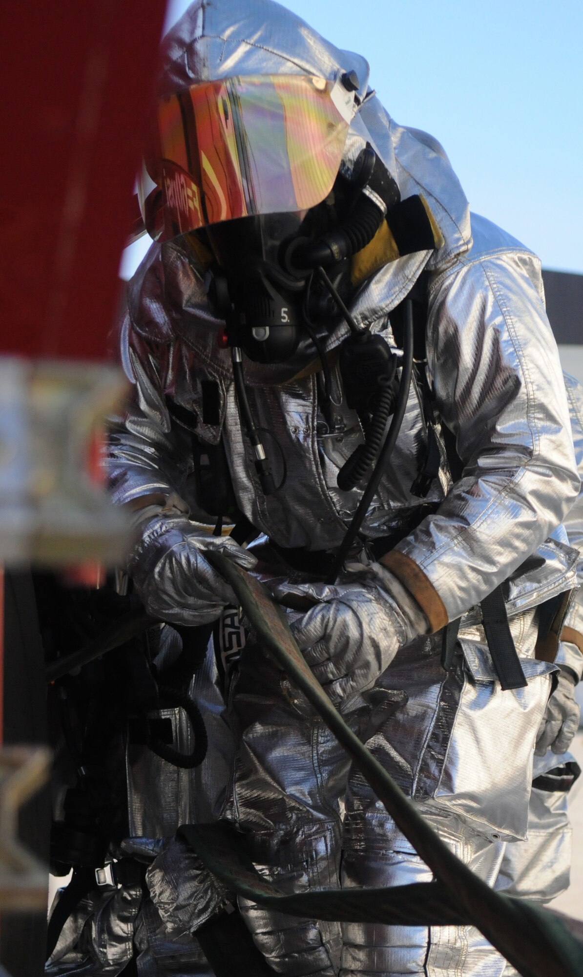 SPANGDAHLEM AIR BASE, Germany – A 52nd Civil Engineer Squadron firefighter pulls in the fire hose after responding to a simulated fire during Operation Saber Crown 10-04 March 3. The Phase II exercise evaluated the wing’s self-aid and buddy care execution, emergency response and chemical, biological, radiological, nuclear and explosive procedures to prepare for the upcoming NATO force evaluation. (U.S. Air Force photo/Airman 1st Class Staci Miller)