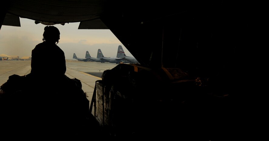 U.S. Air Force Airman 1st Class Kameron Trout, loadmaster, 774th Expeditionary Airlift Squadron, deployed to Bagram Airfield, Afghanistan, watches as a C-130H Hercules prepares to take off before airdropping  low-cost low-altitude re-supply bundles, Feb. 6, 2010. The mission marked the first time an Air Force C-130 crew airdropped LCLA bundles in a combat zone.  (U.S. Air Force photo/Staff Sgt. Angelita Lawrence/released)