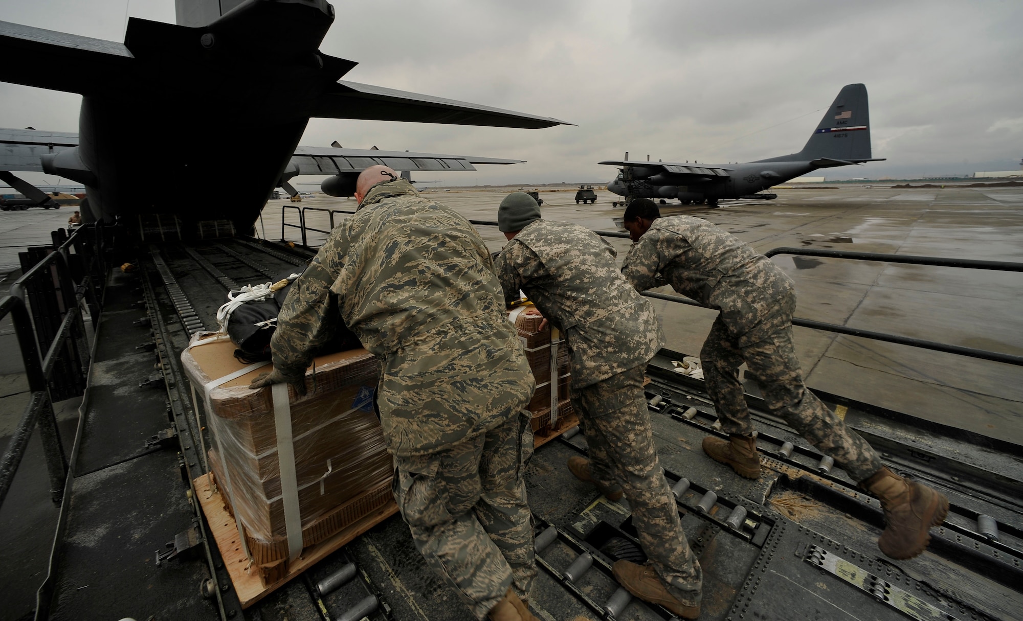 U.S. Air Force Airmen and two U.S. Army soldiers deployed to Bagram Airfield, Afghanistan, load, a C-130H Hercules with low-cost low-altitude resupply bundles, Feb. 6, 2010. This mission marked the first time an Air Force C-130 crew airdropped LCLA bundles in a combat zone.  (U.S. Air Force photo/Staff Sgt. Angelita Lawrence/released)

