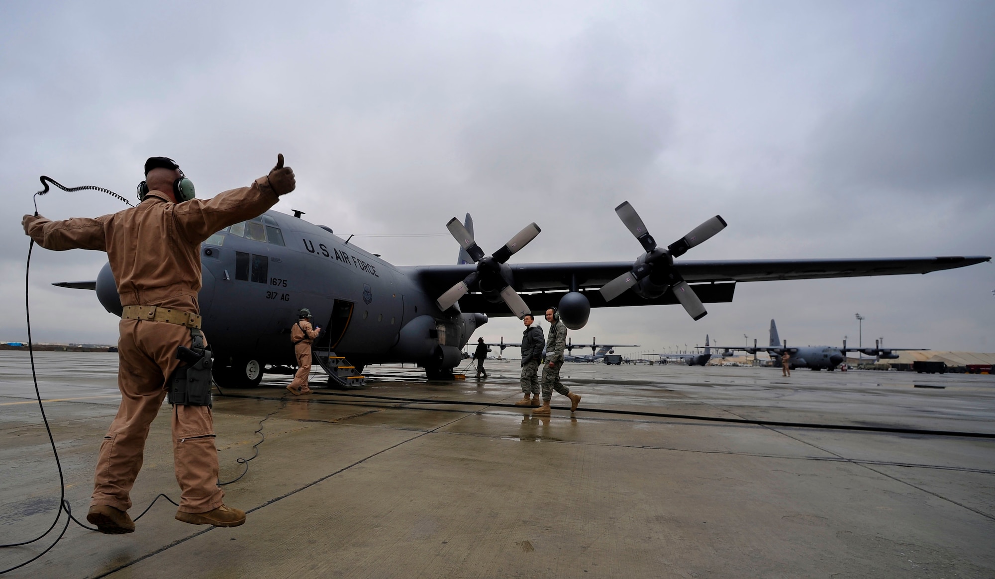 U.S. Air Force Tech. Sgt. Andrew Briggs, loadmaster, 774th Expeditionary Airlift Squadron, deployed to Bagram Airfield, Afghanistan, gives a signal to release the chalks on a C-130H Hercules before the crew flies a mission to airdrop four low-cost low-altitude re-supply bundles, Feb. 6, 2010. This mission marked the first time an Air Force C-130 crew airdropped LCLA bundles in a combat zone.   (U.S. Air Force photo/Staff Sgt. Angelita Lawrence/released)
