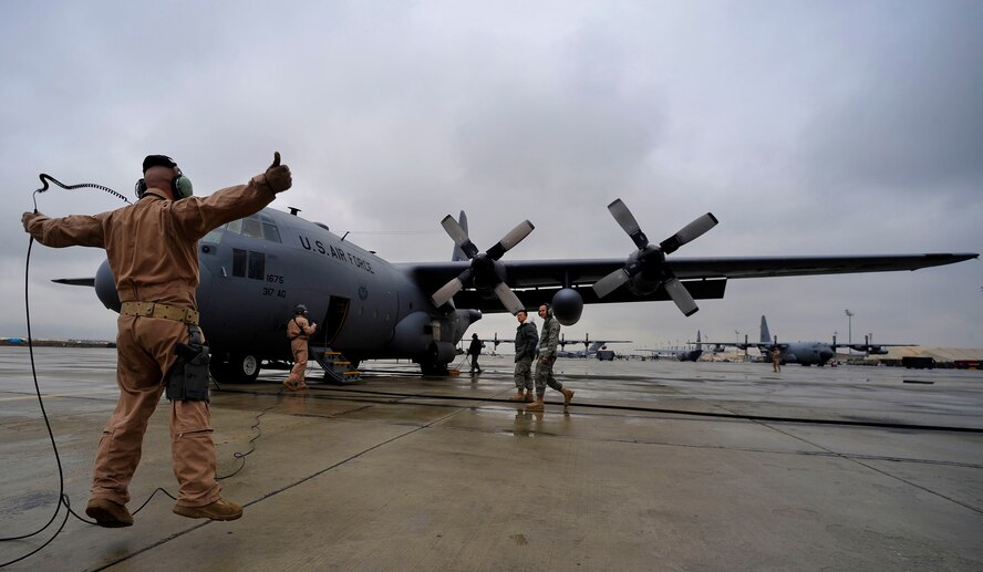U.S. Air Force Tech. Sgt. Andrew Briggs, loadmaster, 774th Expeditionary Airlift Squadron, deployed to Bagram Airfield, Afghanistan, gives a signal to release the chalks on a C-130H Hercules before the crew flies a mission to airdrop four low-cost low-altitude re-supply bundles, Feb. 6, 2010. This mission marked the first time an Air Force C-130 crew airdropped LCLA bundles in a combat zone.   (U.S. Air Force photo/Staff Sgt. Angelita Lawrence/released)