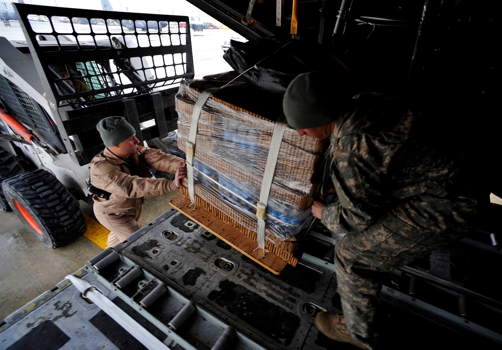 U.S. Air Force Master Sgt. Clay Holt, loadmaster, 774th Expeditionary Airlift Squadron, deployed to Bagram Airfield, Afghanistan, helps U.S. Army Sgt. Matthew Davenport, out-load NCO, Combined Joint Special Operations Task Force Afghanistan, load a C-130H Hercules with low-cost low-altitude re-supply bundles, Feb. 6, 2010. This mission marked the first time an Air Force C-130 crew airdropped LCLA bundles in a combat zone.  (U.S. Air Force photo/Staff Sgt. Angelita Lawrence/released)


