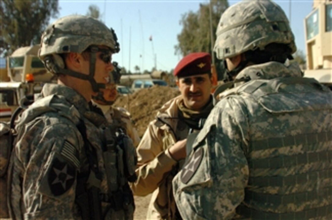 U.S. Army soldiers of Charlie Troop, 1st Battalion, 14th Cavalry Regiment, 2nd Infantry Division talk to an Iraqi Police officer to make preparations for a joint patrol in Asruyah, Iraq, on Feb. 8, 2010.  U.S. soldiers show support for the Iraqi army by escorting them through a local farming village in Asruyah.  