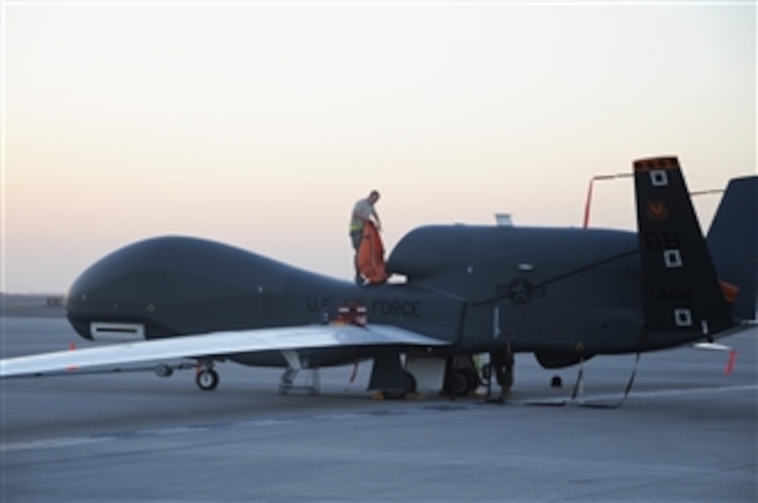 U.S. Air Force Staff Sgt. Michael Goenner, a crew chief with the 380th Expeditionary Aircraft Maintenance Squadron, performs a preflight inspection while standing on the fuselage of an RQ-4 Global Hawk aircraft at a location in Southwest Asia prior to a combat mission on Feb. 12, 2010.  