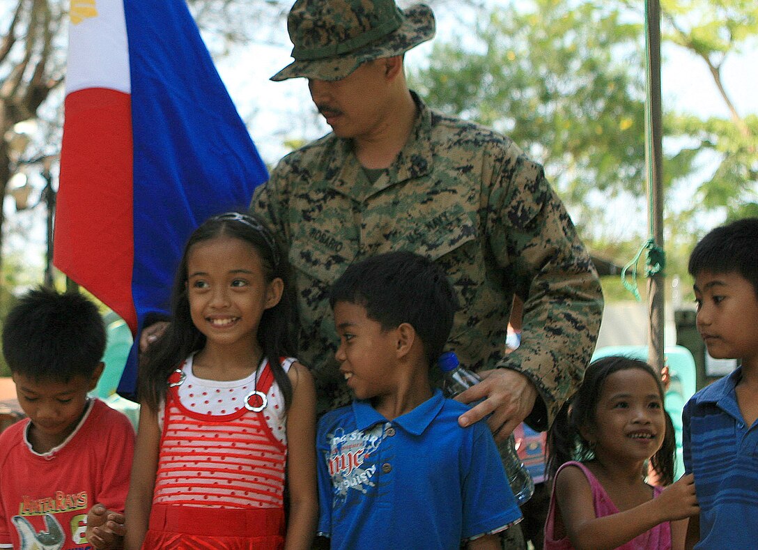 Chief Petty Officer Joshua Rosario, a hospital corpsman chief with Combat Logistics Battalion 31 (CLB-31), 31st Marine Expeditionary Unit (MEU), positions students with Marnay Primary School for a group photo, March 5. Marines and sailors with CLB-31 are rebuilding a two-room classroom at Marnay Primary School during exercise Balikatan 2010 (BK ’10). Servicemembers from the Armed Forces of the Philippines (AFP) and the U.S. are working together during BK ’10 to hone their civil-military interoperability skills to ensure more responsive, efficient and effective relief efforts. (Official Marine Corps photo by Lance Cpl. Dengrier M. Baez)::r::::n::