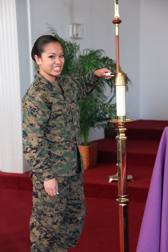 Petty Officer 3rd Class Analiza R. Gordy, a religious program specialist, posses for a photo in the main chapel, March 5. Gordy performs many duties in her job one of which is lighting the candles before each service.