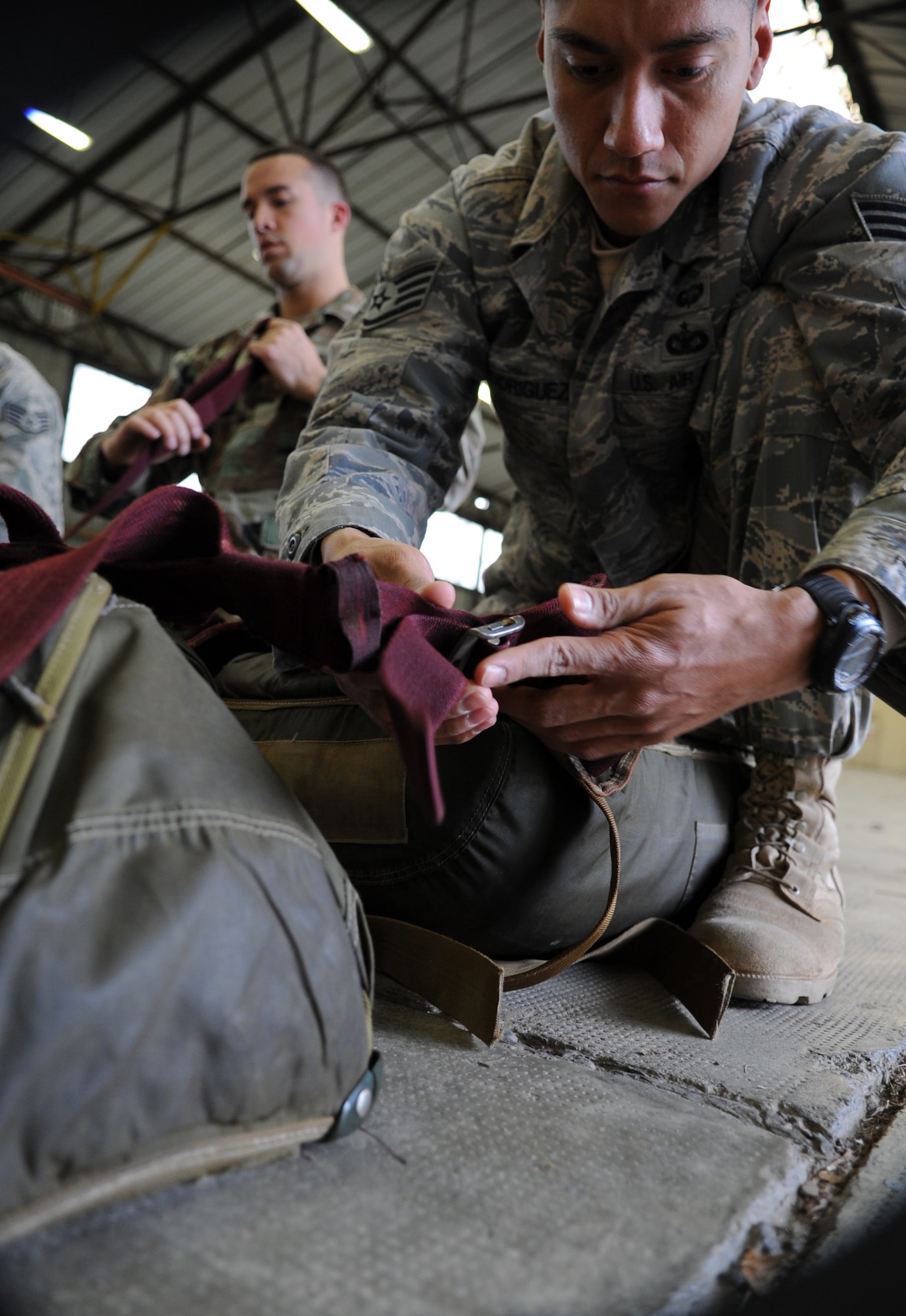 U.S. Air Force Staff Sgt. Gabriel Rodriguez, with the 435th Security Forces Squadron, prepares a chute for a static jump during a pre-jump training at École des troupes aéroportées (ETAP) Pau, France, March 3, 2010. Members of the 435th Contingency Response Group and the 5th Quartermaster Company joined with their French military counterparts for a week of training at the École des troupes aéroportées (ETAP), or School of Airborne Troops, a military school dedicated to training the military paratroopers  the French army, located in the town of Pau, in the département of Pyrénées-Atlantiques, France.  The ETAP is responsible for training paratroopers, and for international cooperation and promotion of paratroop culture. (U.S. Air Force photo by Airman 1st Class Caleb Pierce)
