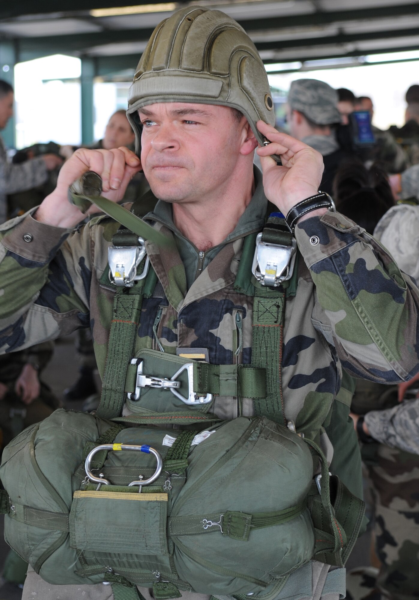 French Marine Maj. Yann Le Bastard, free fall instructor at École des troupes aéroportées (ETAP), puts on his helmet in preparation to a static jump from a C-130J Super Hercules at École des troupes aéroportées (ETAP) Pau, France, March 2, 2010. Members of the 435th Contingency Response Group and the 5th Quartermaster Company joined with their French military counterparts for a week of training at the École des troupes aéroportées (ETAP), or School of Airborne Troops, a military school dedicated to training the military paratroopers  the French army, located in the town of Pau, in the département of Pyrénées-Atlantiques, France.  The ETAP is responsible for training paratroopers, and for international cooperation and promotion of paratroop culture. (U.S. Air Force photo by Airman 1st Class Caleb Pierce)