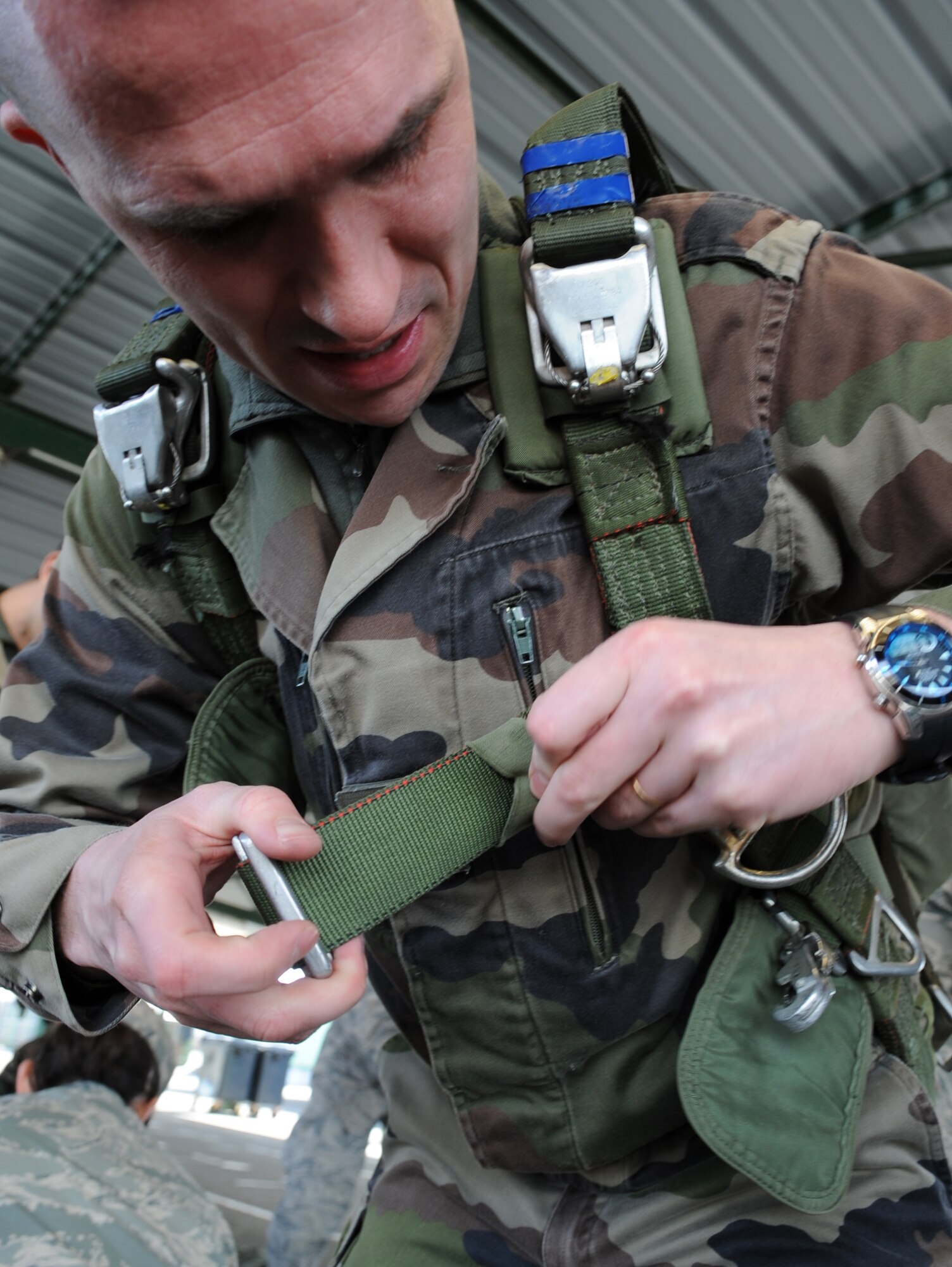 French Airborne member adjust his chute to properly fit prior to a static jump from a C-130J Super Hercules at École des troupes aéroportées (ETAP) Pau, France, March 2, 2010. Members of the 435th Contingency Response Group and the 5th Quartermaster Company joined with their French military counterparts for a week of training at the École des troupes aéroportées (ETAP), or School of Airborne Troops, a military school dedicated to training the military paratroopers  the French army, located in the town of Pau, in the département of Pyrénées-Atlantiques, France.  The ETAP is responsible for training paratroopers, and for international cooperation and promotion of paratroop culture. (U.S. Air Force photo by Airman 1st Class Caleb Pierce)