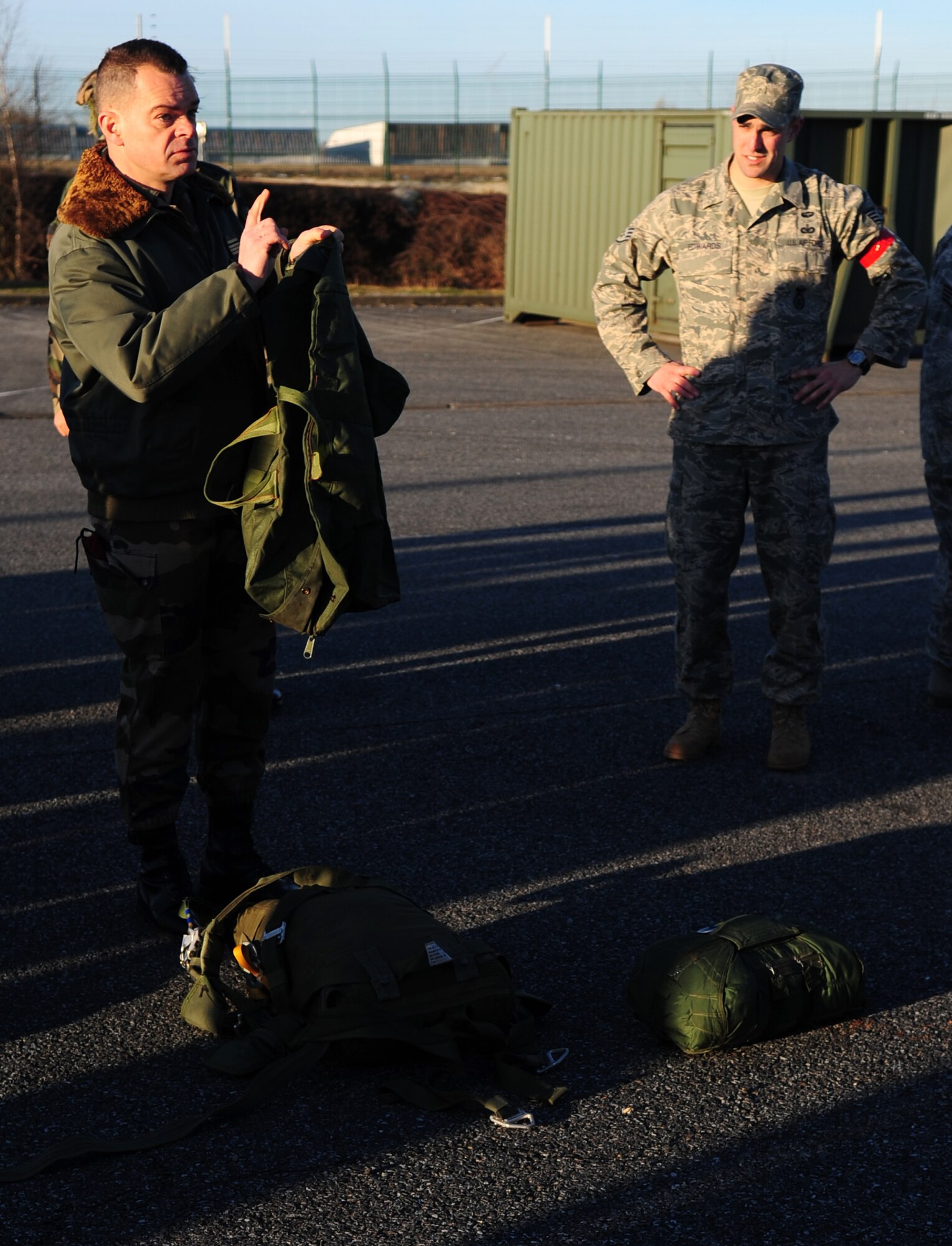 French Marine Major Yann Le Bastard, a freefall instructor provides translation for French paratroopers that are being trained and preparing to jump from a U.S. Military aircraft, using U.S. Military parashoots on March 2, 2010. Members of the 435th Contingency Response Group and the 5th Quartermaster Company joined with their French military counterparts for a week of training at the École des troupes aéroportées (ETAP), or School of Airborne Troops, a military school dedicated to training the military paratroopers   of the French army, located in the town of Pau, in the département of Pyrénées-Atlantiques, France.  The ETAP is responsible for training paratroopers, and for international cooperation and promotion of paratroop culture. (U.S. Air Force Photo by Staff Sgt. Jocelyn Rich)