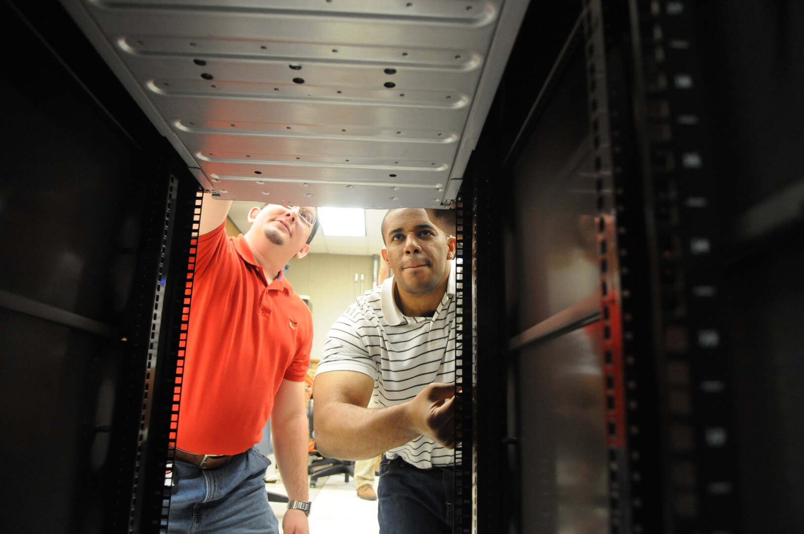 Adrian McLure (right) and Keith Epson, 902nd Communications Squadron, prepare the equipment to be used for the upcoming e-mail migration on Randolph. (U.S. Air Force photo by Rich McFadden)