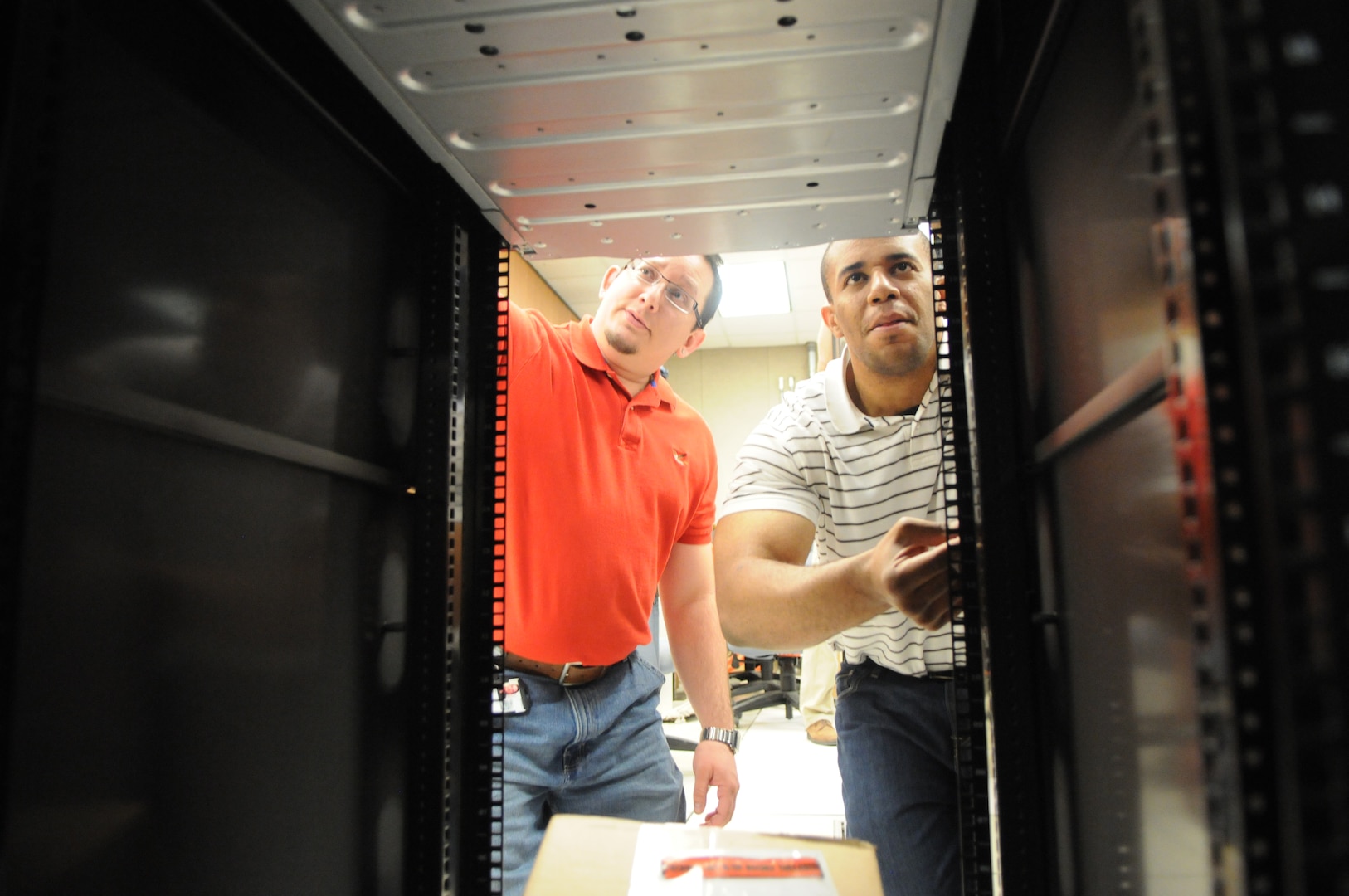 Adrian McLure (right) and Keith Epson, 902nd Communications Squadron, prepare the equipment to be used for the upcoming e-mail migration on Randolph. (U.S. Air Force photo by Rich McFadden)