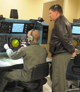 Maj. Michael Cavanaugh, 562nd Flying Training Squadron flight instructor at Randolph Air Force Base, TX., instructs 2nd Lt. Andrew Vogel on the procedures for operating the T-45 Simulator. (U.S. Air Force Photo by Joel Martinez)