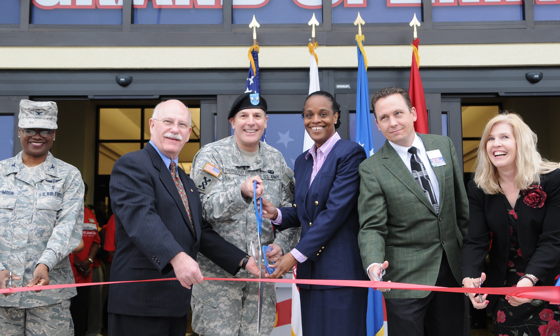 Doors to the new Randolph Air Force Base Exchange opened March 5, with a ribbon cutting ceremony. Event officials cutting the ribbon are (L-R), Col. Soledad Lindo-Moon, 359th Medical Group commander, Robert Graves, Army Maj. Gen. Keith Thurgood, Army and Air Force Exchange Service commander, Shelly Armstrong, Mike Einer, and Mrs. Darllene Kullberg. The new Building is AAFES' first environmentally friendly "green" BX, using energy-effecient glass, lighting, 40 percent recycled material carpet, and HVAC system to reduce the overall operating cost.(U.S. Air Force Photo By Don Lindsey)