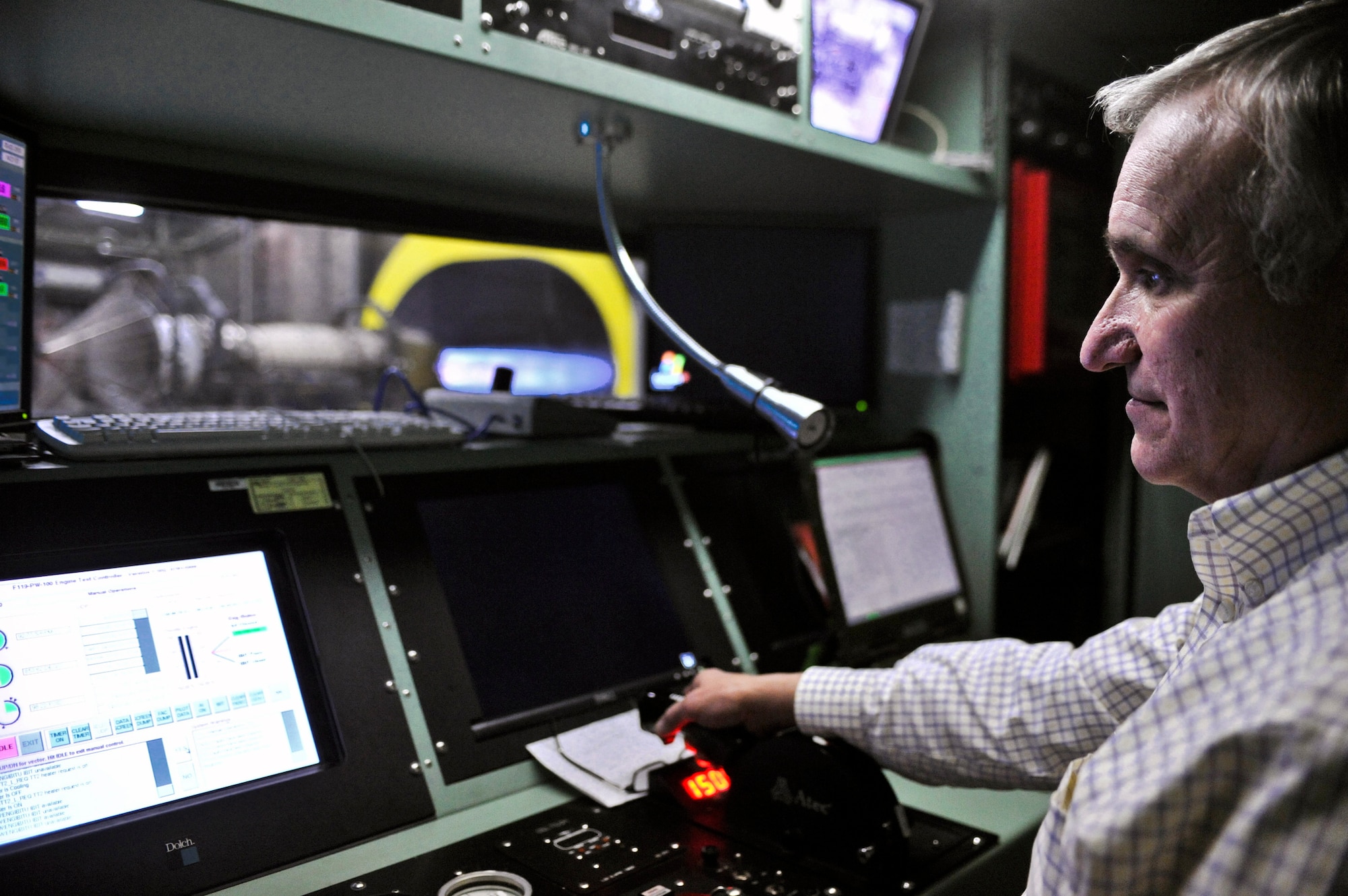 ELMENDORF AIR FORCE BASE, Alaska – Gary Warmath, 3rd Component Maintenance Squadron Propulsion Flight, controls the throttle on a jet engine while in the control booth, March 2. From this angle Warmath can view the engine through the window and from several different angles on a monitor located over his head. He can also closely watch the many different functions of the motor by viewing several different monitors. (Air Force photo by Airman 1st Class Christopher Gross)
