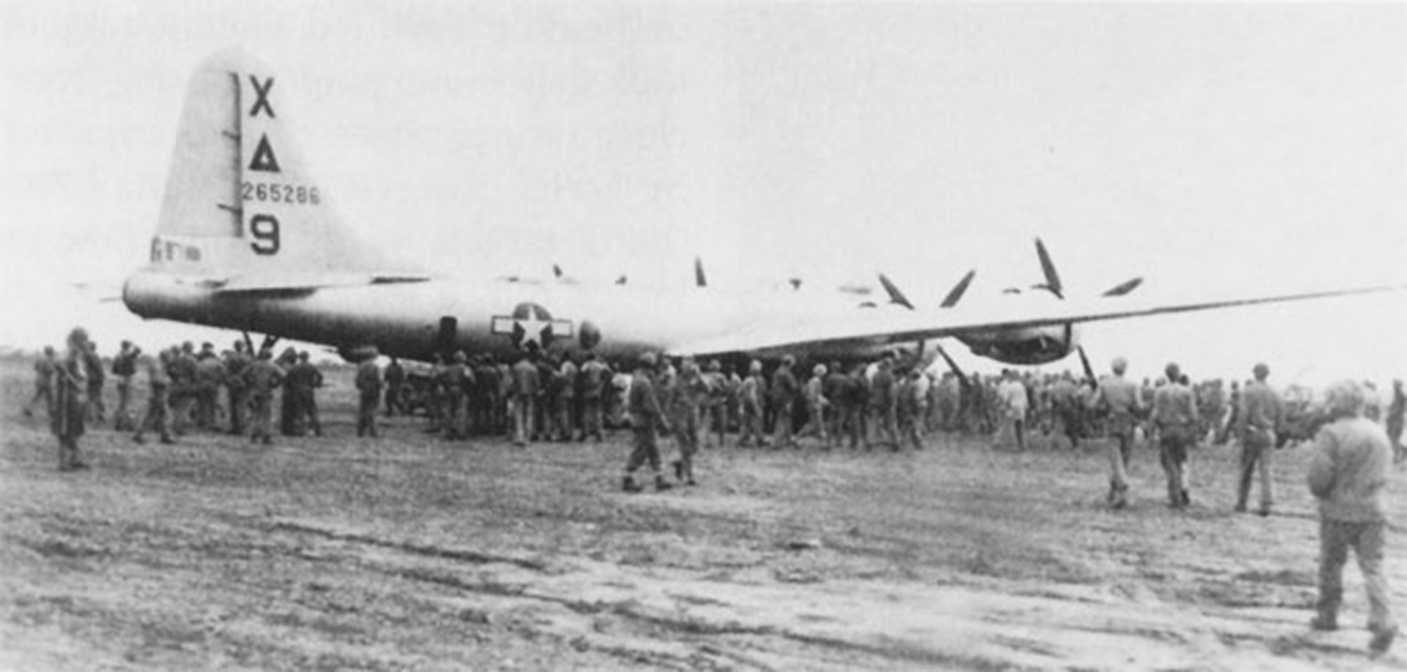 "Dinah Might," the first crippled B-29 to make an emergency landing on Iwo Jima during the fighting, is surrounded by Marines and Seabees on 4 March 1945.
Department of Defense Photo (USMC) 112392 
