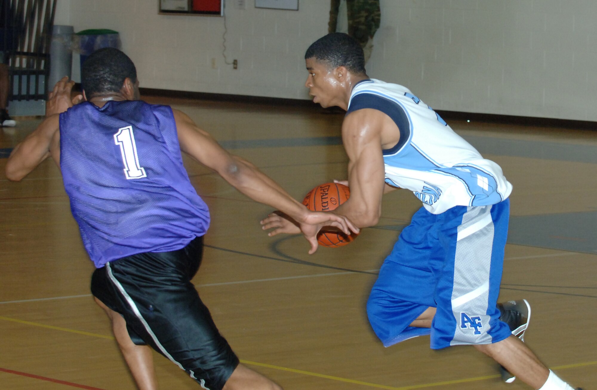 LANGLEY AIR FORCE BASE, Va. -- Air Force Targeting Center Small Forward Drew Colen drives past 1st Equipment Maintenance Squadron Guard Preston Griffin in an intramural basketball play-off game March 4 at the Shellbank Fitness Center. AFTC won the game, 65-58. (U.S. Air Force photo/Airman 1st Class Jason J. Brown)