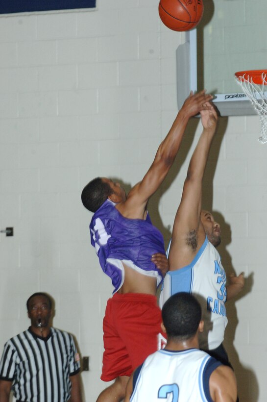 LANGLEY AIR FORCE BASE, Va. -- 1st Equipment Maintenance Squadron Forward Michael Martin attempts a shot over Air Force Targeting Center Power Forward Greg Montgomery in an intramural basketball play-off game March 4 at the Shellbank Fitness Center. AFTC won the game, 65-58. (U.S. Air Force photo/Airman 1st Class Jason J. Brown)