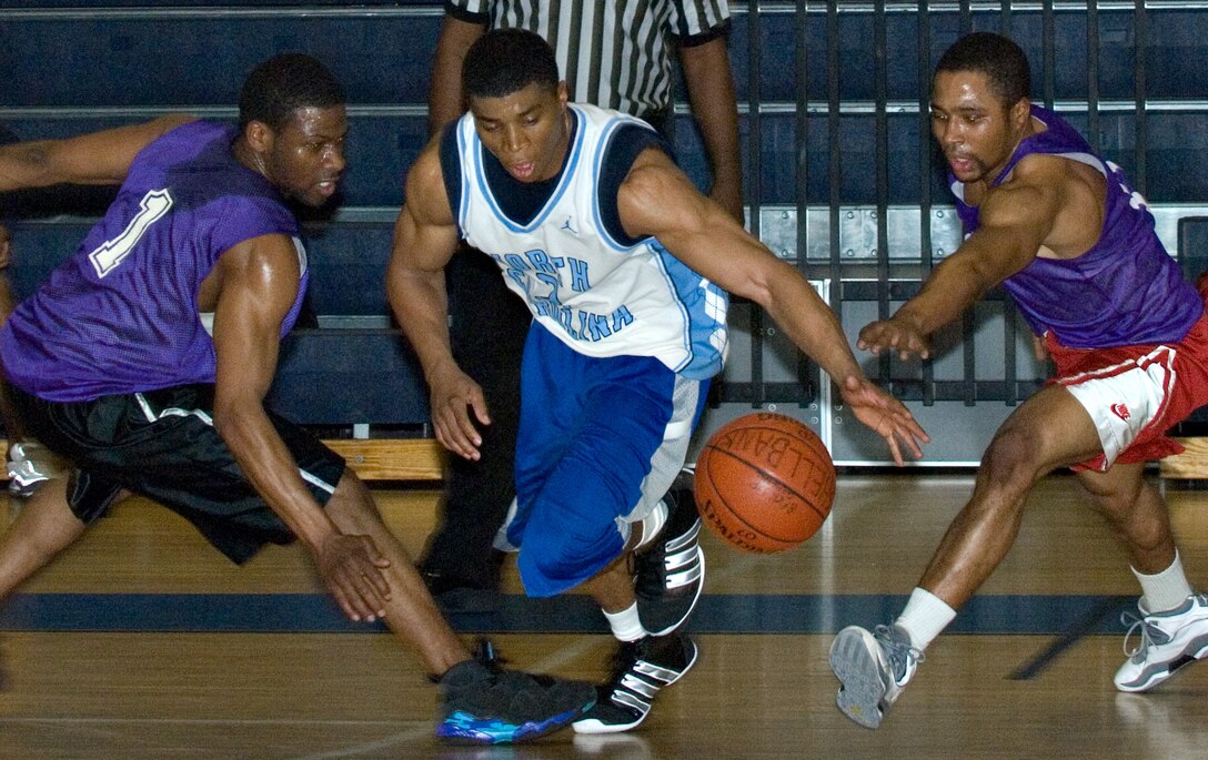 LANGLEY AIR FORCE BASE, Va. -- Air Force Targeting Center Small Forward Drew Colen splits two 1st Equipment Maintenance Squadron defenders in an intramural basketball play-off game March 4 at the Shellbank Fitness Center. AFTC won the game, 65-58. (U.S. Air Force photo/Airman 1st Class Jason J. Brown)