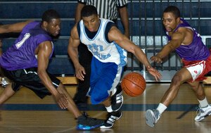LANGLEY AIR FORCE BASE, Va. -- Air Force Targeting Center Small Forward Drew Colen splits two 1st Equipment Maintenance Squadron defenders in an intramural basketball play-off game March 4 at the Shellbank Fitness Center. AFTC won the game, 65-58. (U.S. Air Force photo/Airman 1st Class Jason J. Brown)