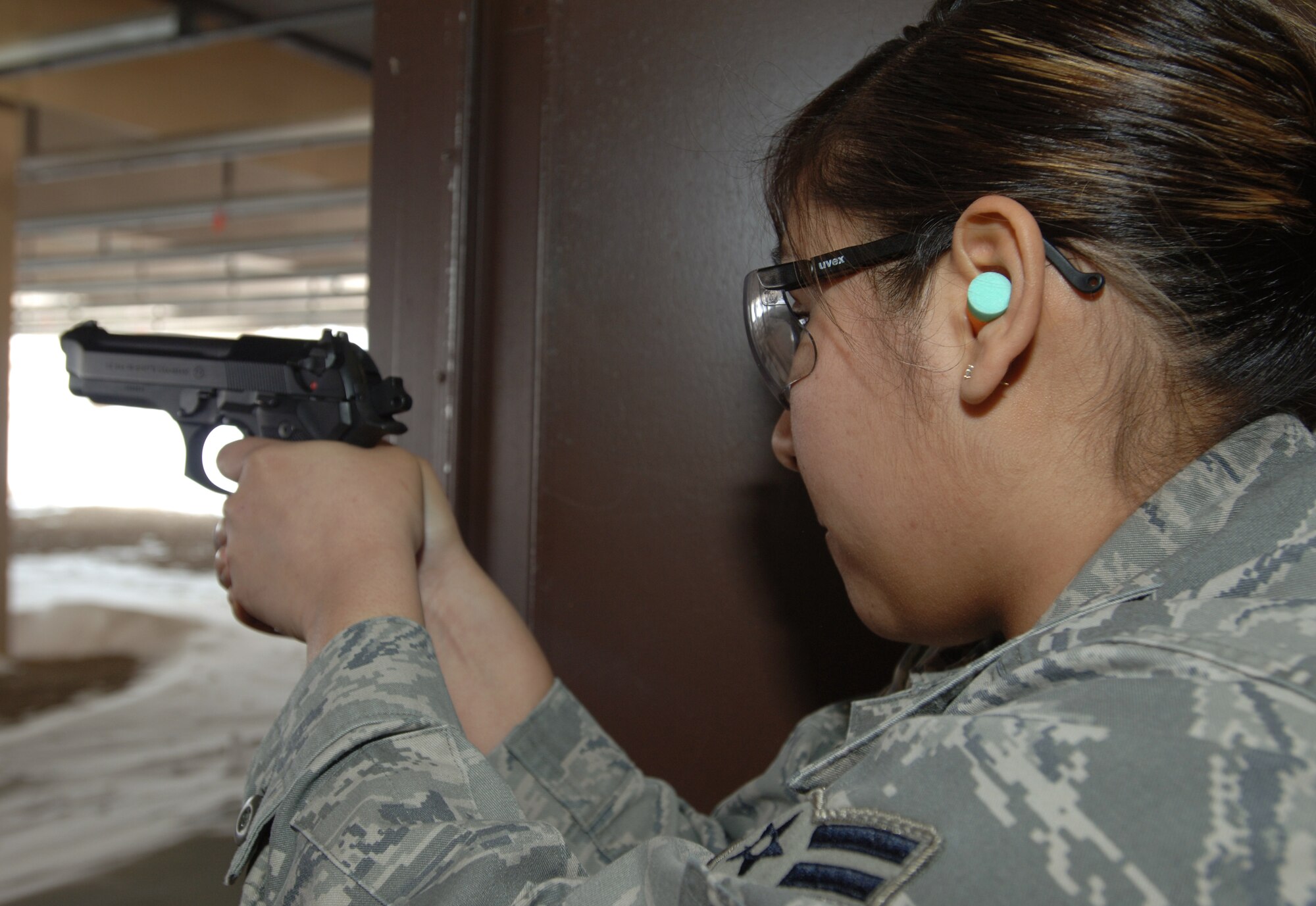 Airman 1st Class Zelda Hernandez, 319th Communications Squadron, fires an M-9 pistol during combat arms training March 2 at the Grand Forks Air Force Base Firing Range. (U.S. Air Force photo by Airman 1st Class Amber Price)
