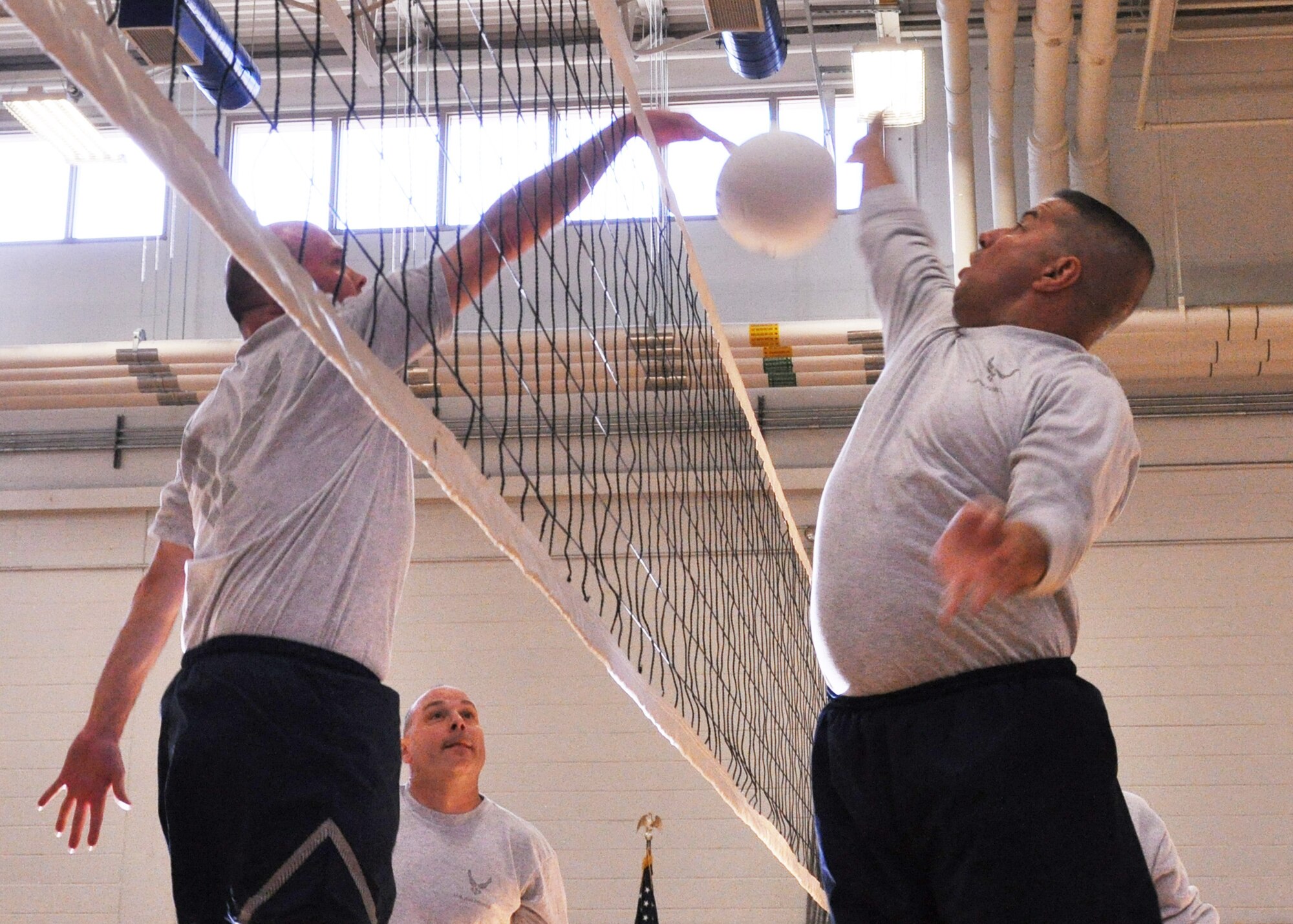EGLIN AIR FORCE BASE, Fla. – Eagles’ player Col. Kevin McElroy (left), 53rd Electronic Warfare Squadron commander, spikes the ball past a Chiefs player during the first game of the 3rd Annual Chiefs vs. Eagles Multi-Sport Tournament March 4, at the Eglin Fitness Center. The tournament pits Eglin’s chief master sergeants against colonels in volleyball, softball, golf and basketball. The Eagles won 3-0 in the best-of-five volleyball match. Their next matchup is a softball game, April 30. (U.S. Air Force photo/ Airman 1st Class Anthony Jennings)
