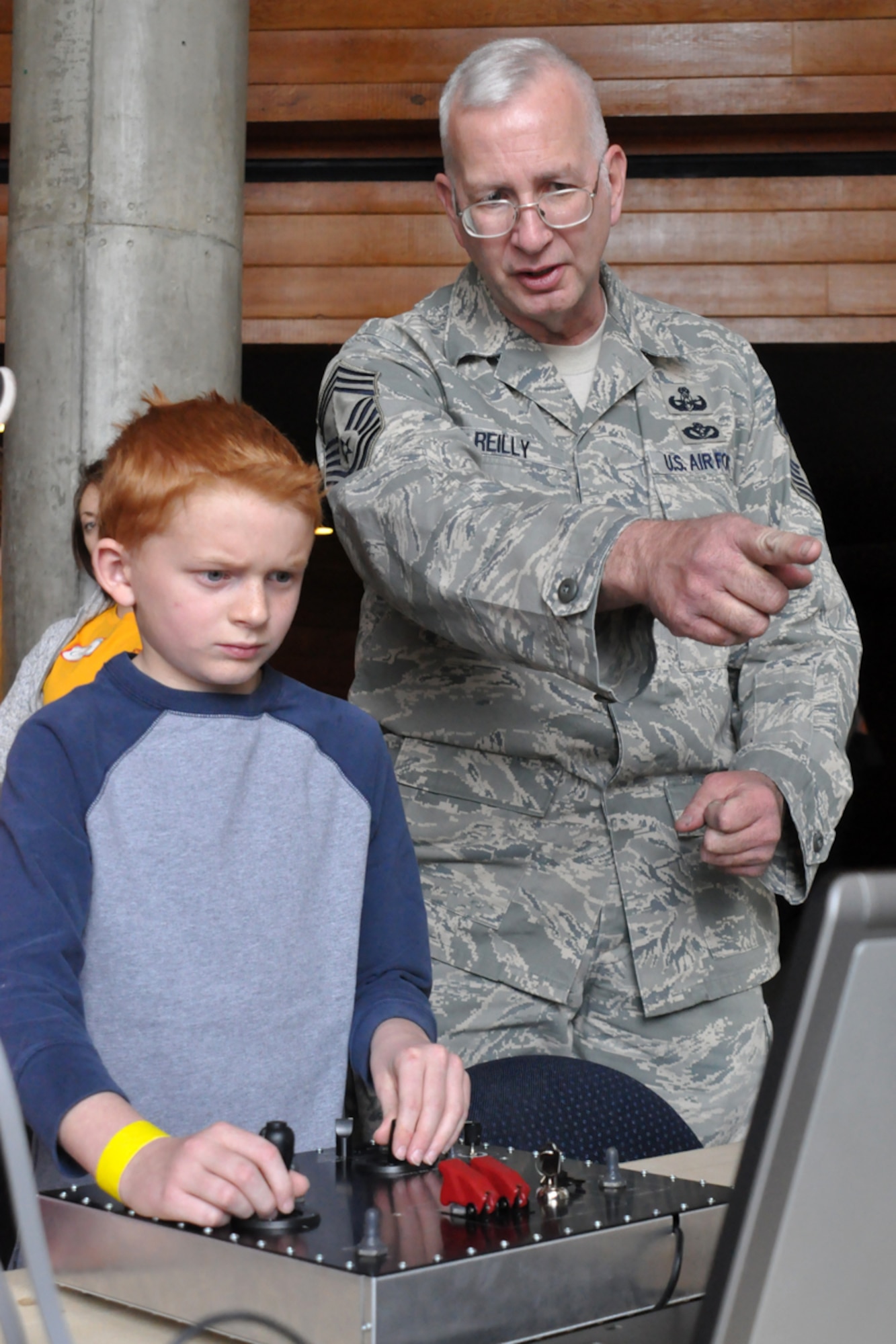 Chief Master Sgt. Michael Reilly, 75th Explosive Ordnance Disposal Flight superintendent, shows Wesley Hosman, 9, how to work a simulator during an EOD demonstration as part of the 419th Fighter Wing’s first-ever Yellow Ribbon Reintegration event Feb. 28.  (U.S. Air Force photo/Staff Sgt. Heather Skinkle)