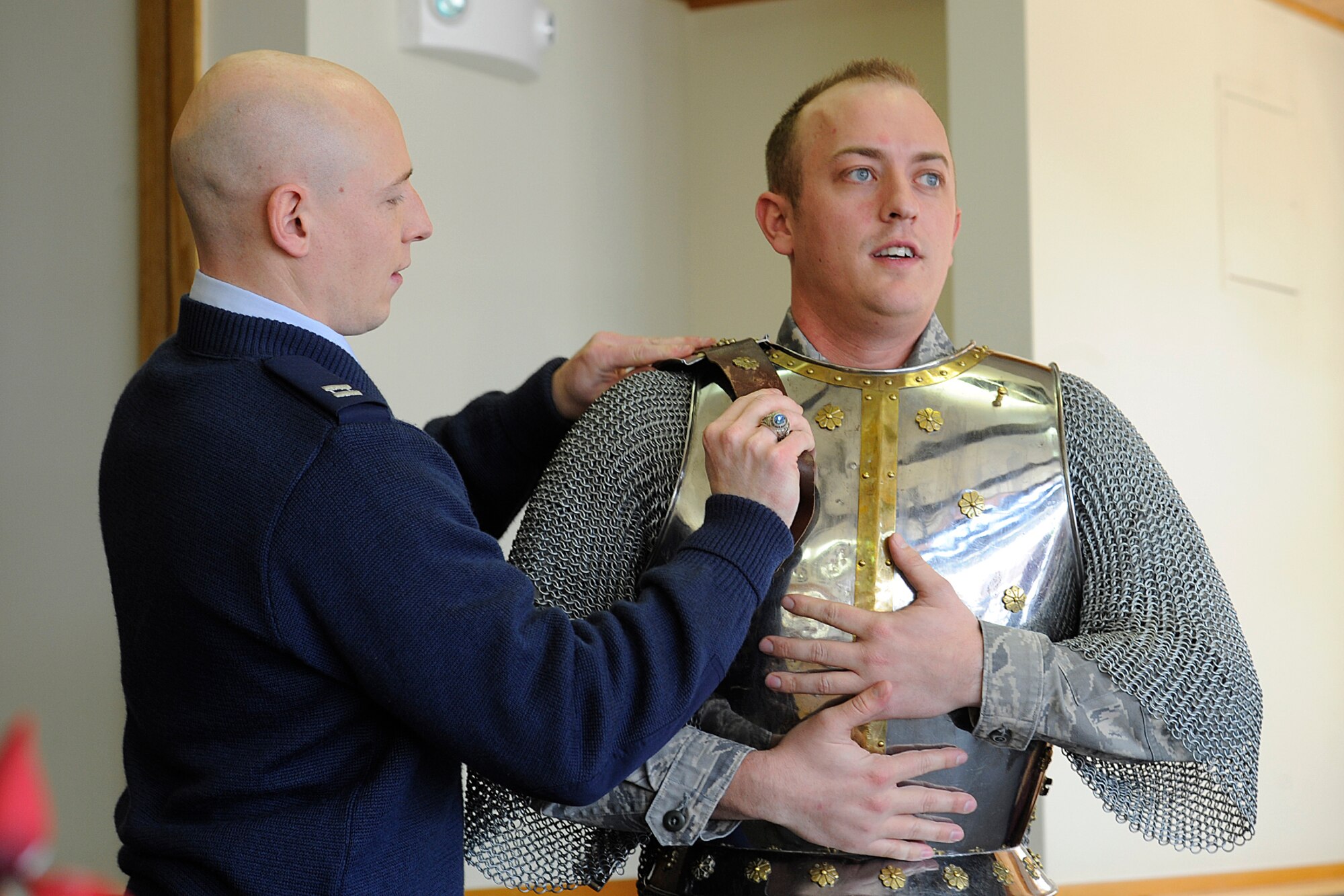 Capt. Jesse Johnson, 21st Force Support Squadron (left), helps Staff Sgt. Josh Kennedy, 21st Space Wing Office of the Staff Judge Advocate paralegal, into his suit of armor March 1. Sergeant Kennedy accepted the role of “Iron Mike,” the 21st Space Wing’s mascot, and will represent the wing during upcoming Guardian Challenge events on Peterson Air Force Base May 19 to 22. Held every two years, Guardian Challenge is the premier space and cyberspace competition in the world. (U.S. Air Force photo/Larry Hulst)