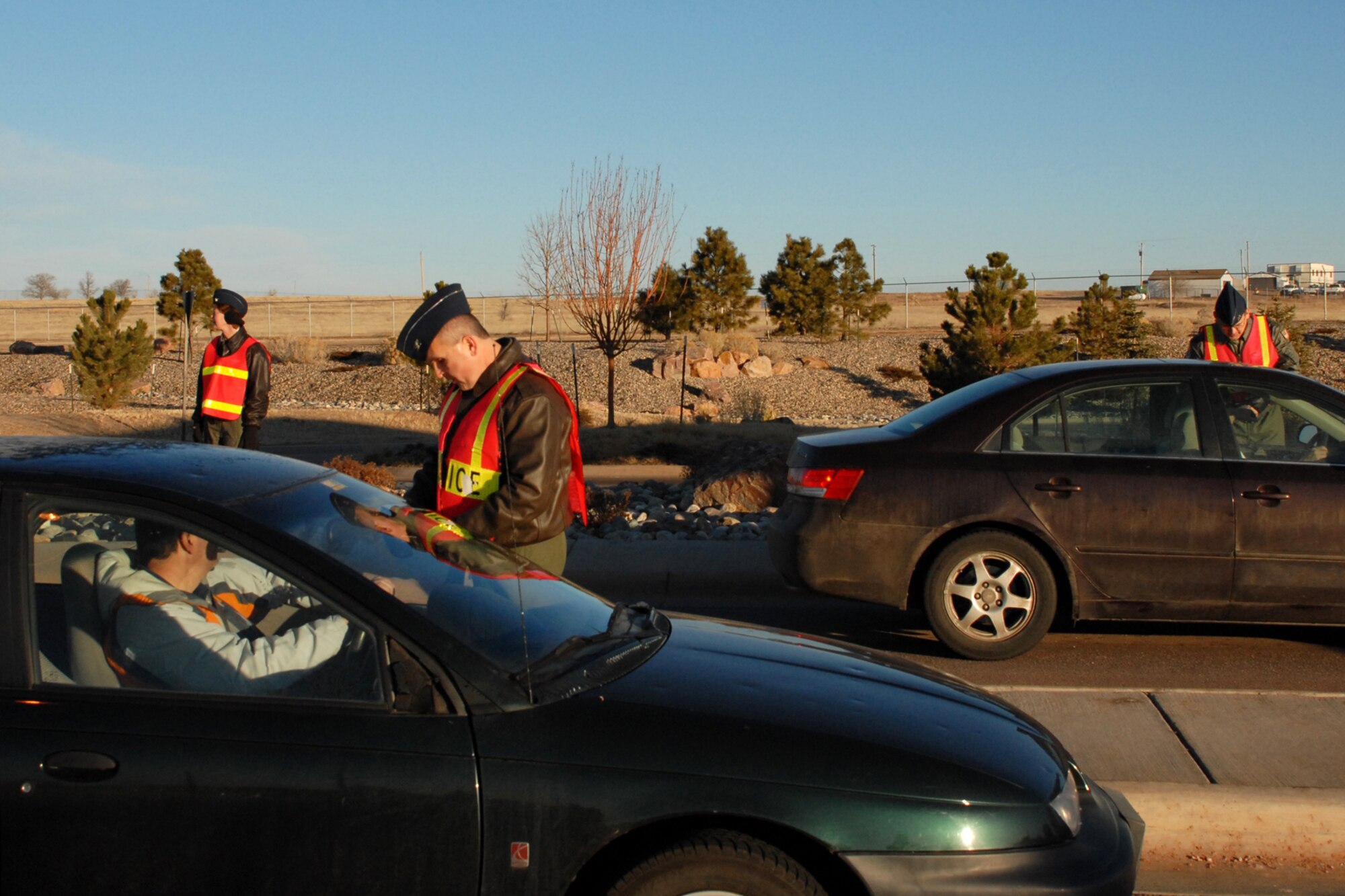 SCHRIEVER AIR FORCE BASE, Colo. -- Col. Karen Rizzuti, 310th Space Wing commander, Col. Shawn Barnes, 595th Space Group commander, and Col. Kevin Cavanagh, 310th Operations Group commander, check Schriever personnel ID cards while performing gate guard duty March 3.  Mission partner commanders were on hand to perform the security detail and welcome Schriever personnel on base.  (U.S. Air Force photo/Staff Sgt. Daniel Martinez)