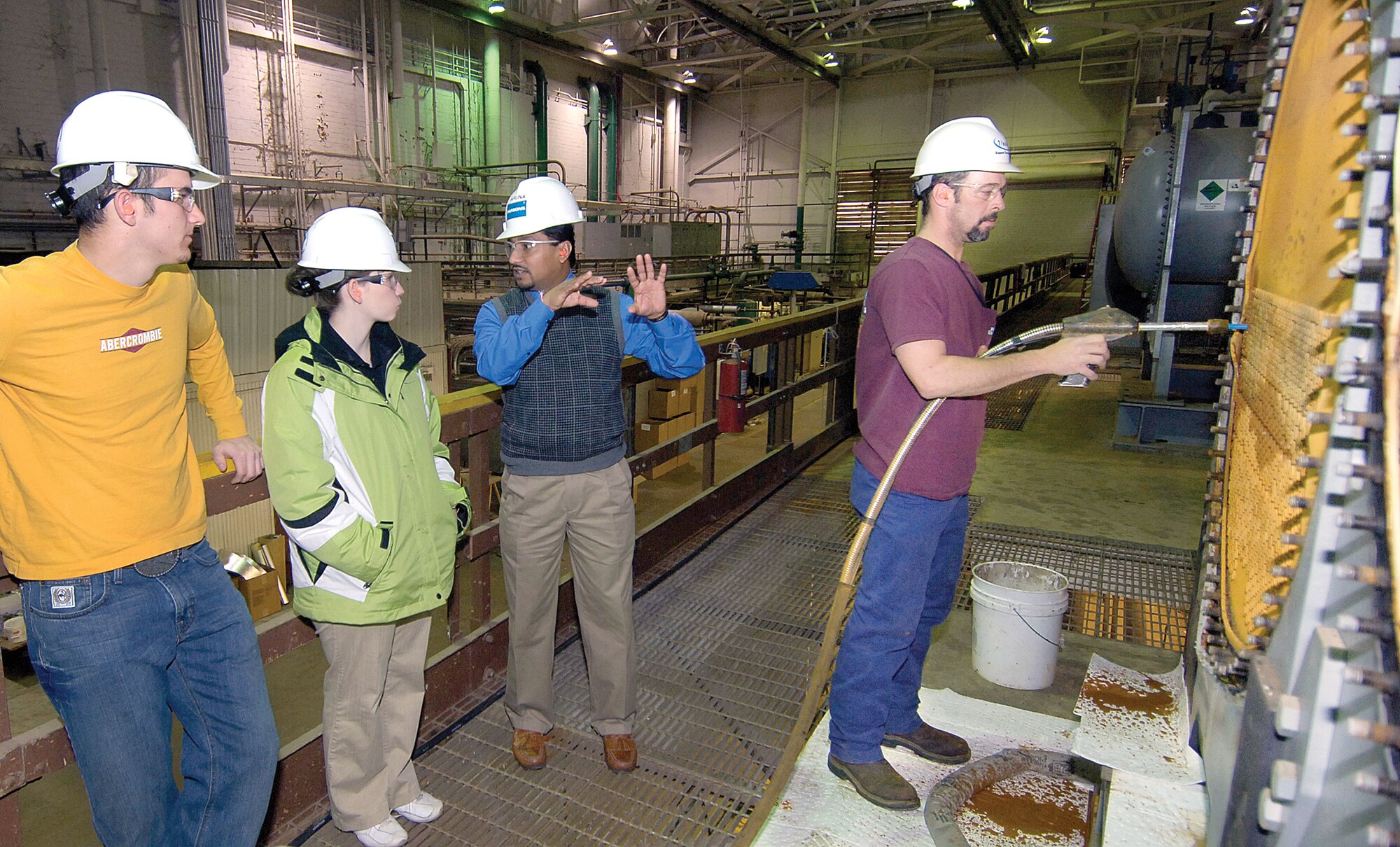Tyler Carpenter, Midwest City High School senior, and Brandi Rehagen , Harrah High School junior, listen to 72nd Civil Engineer mechanical engineer Aruna Abhayagoonawardhana talk about the main boiler plant in Bldg. 3001 while Shawn Barlor uses high pressure water to clean tubes in a chiller.  Mr. Abhayagoonawardhana hosted the students for the Engineer for a Day program during Engineers Week. They visited the Bldg. 2280 paint hangar, shops in Bldg. 9001 and Bldg. 3001 and were welcomed by 72nd Air Base Wing and Tinker Installation Commander Col. Allen Jamerson. (Air Force photo by Margo Wright)
