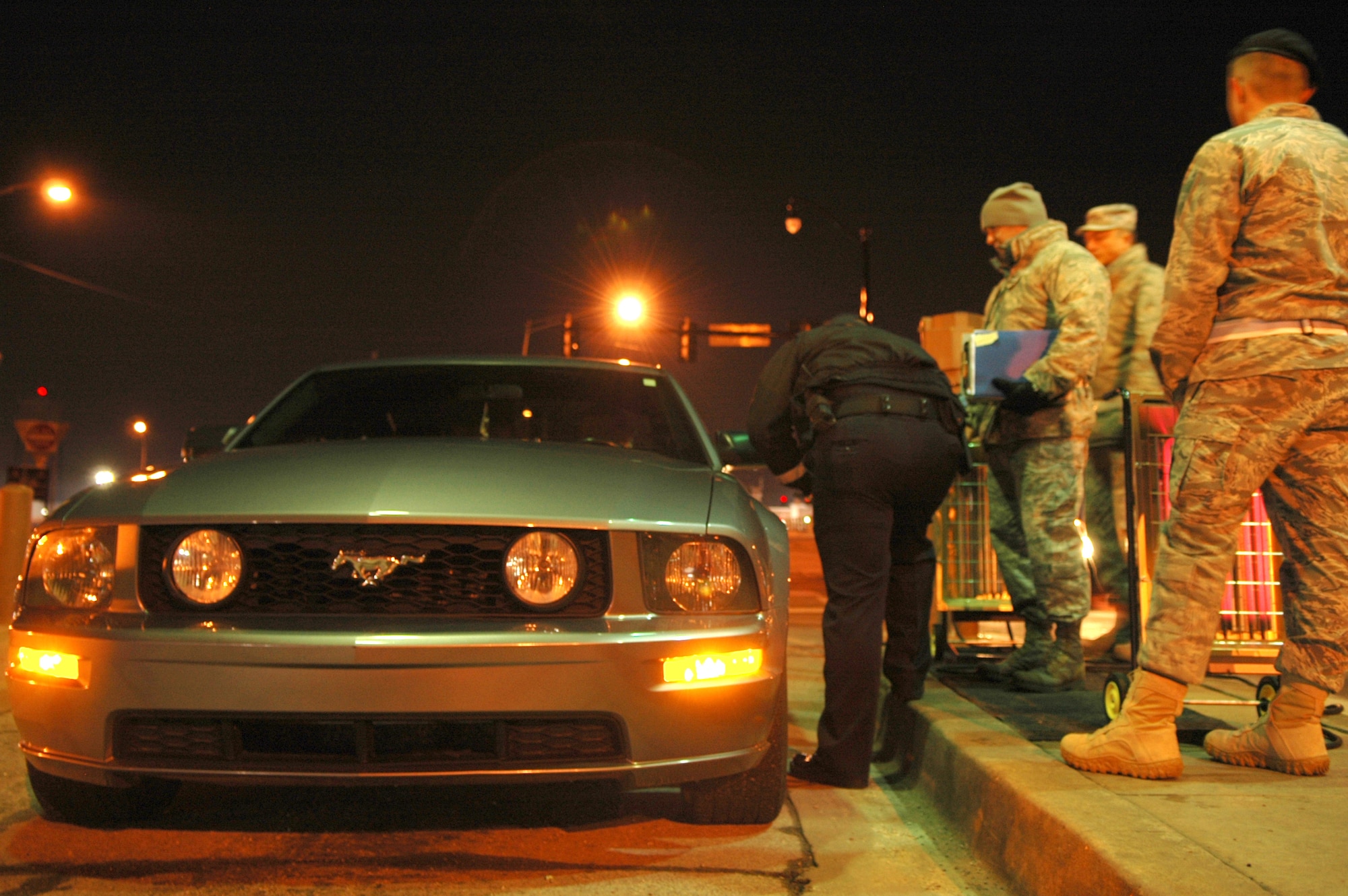 Master Sgts. Brian Brewer and Tate Beaufeaux inform the driver of a vehicle that they have been selected to patriciate in Operation Nighthawk, a random vehicle and drug screening that took place at Tinker between 1 and 3 a.m. Feb. 27. Random drug screenings usually come in the form of a letter. Night time surprise inspections increase the chances of catching recreational drug users. (Air Force photo by Micah Garbarino)