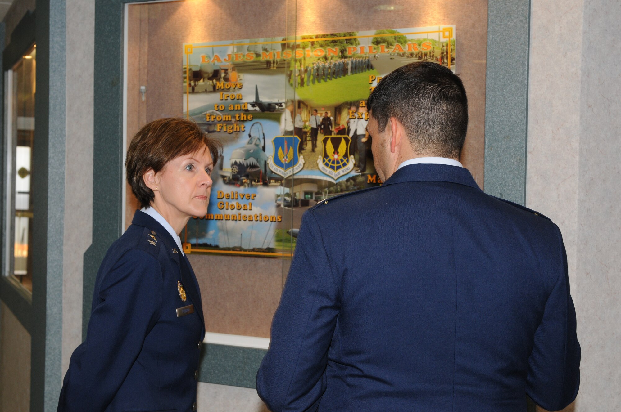 Col. Paul Suarez, 65th Air Base Wing vice commander, explains to Maj. Gen. Judith A. Fedder, former 65th ABW commander, with a poster explaining the missions of the wing during her visit to see Airmen at Lajes Field, Azores, Feb. 24.  General Fedder, the first female commander of the 65th ABW, was a guest speaker at the wing’s annual award ceremony. (U.S. Air Force photo/Guido Melo)
