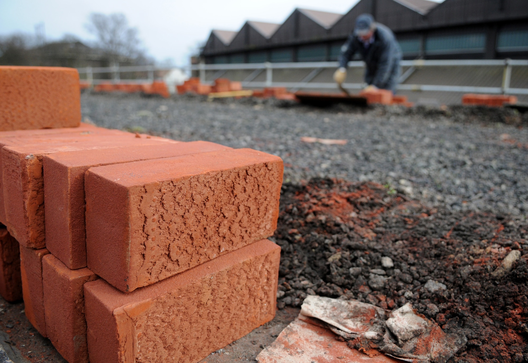 RAF MILDENHALL, England – Bricks sit waiting while Dave Garrett, a contracted mason worker, lays them out on top of Building 514 for a reroofing project March 3. (U.S. Air Force photo/ Staff Sgt. Jerry Fleshman)