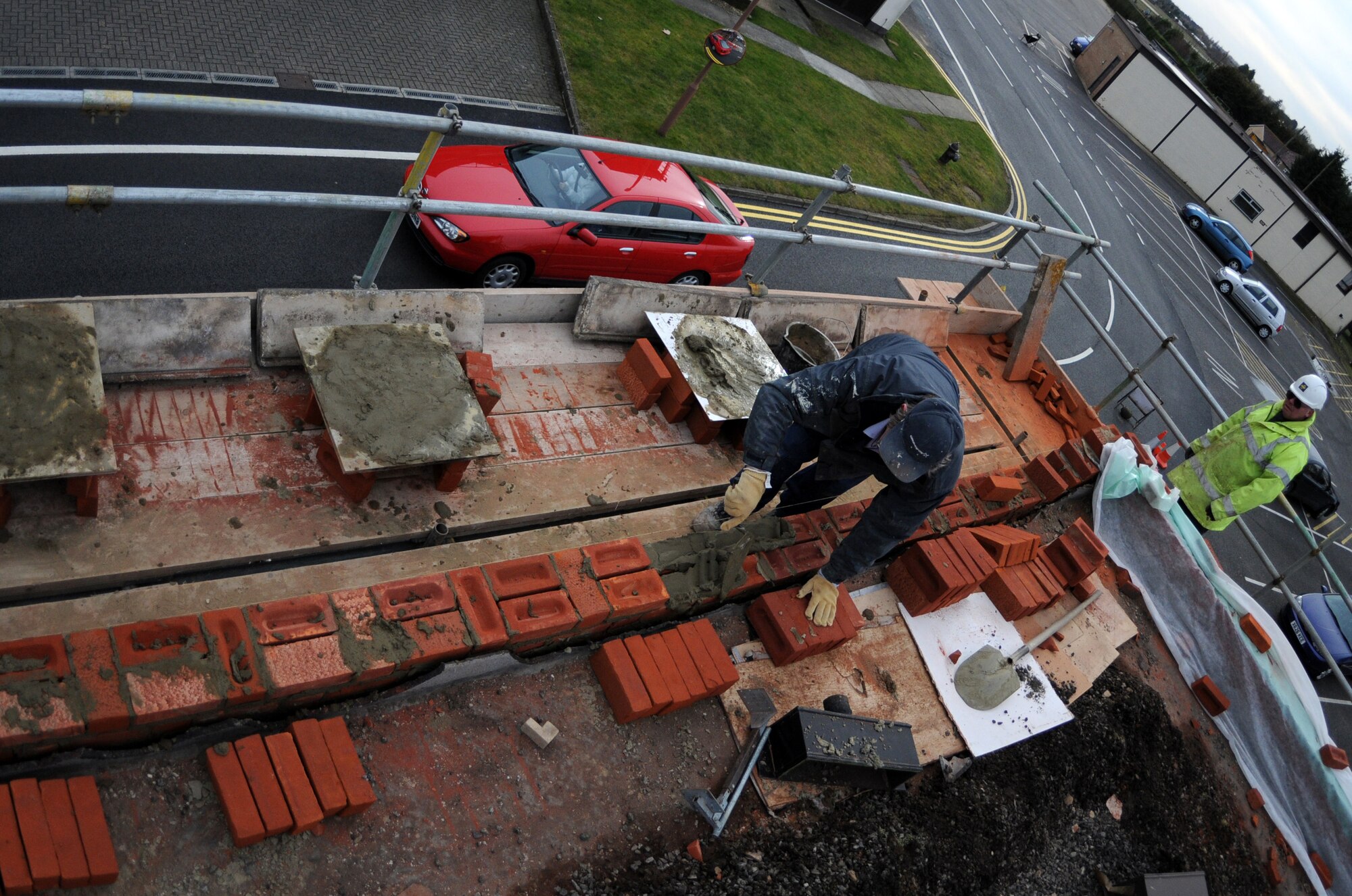 RAF MILDENHALL, England – Dave Garrett, lays down new bricks on the top of Building 514 during a reroofing project March 3. Each brick is hand-laid making precise measurements crucial to building a wall. (U.S. Air Force photo/ Staff Sgt. Jerry Fleshman)