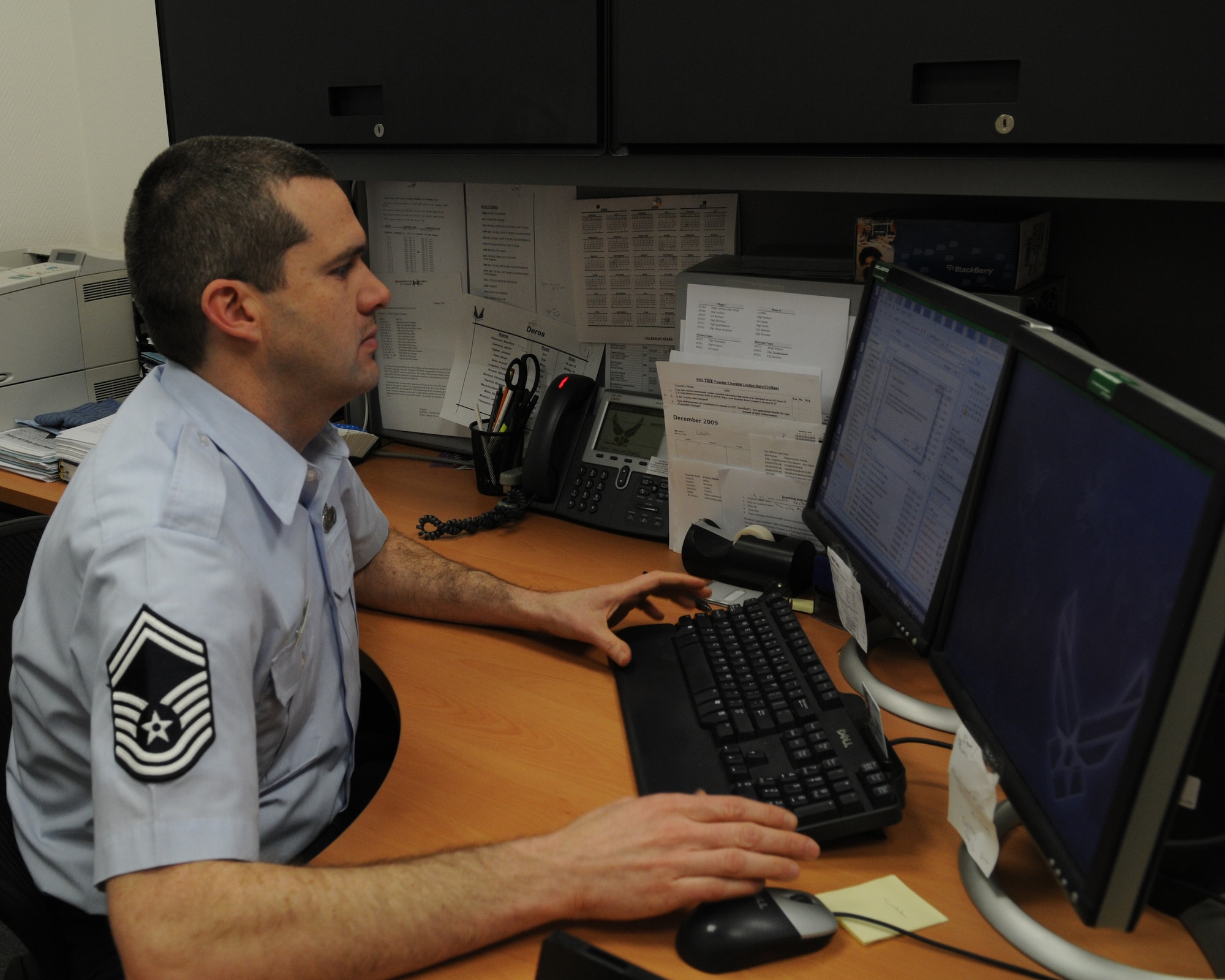 U.S. Air Force Senior Master Sgt. Barton Rudolph, 86th Comptroller Squadron deputy finance services officer works at his desk, Ramstein Air Base, Germany. The finance office serves over 50,000 customers annually. (U.S. Air Force photo by Airman 1st Class Alexandria Mosness)