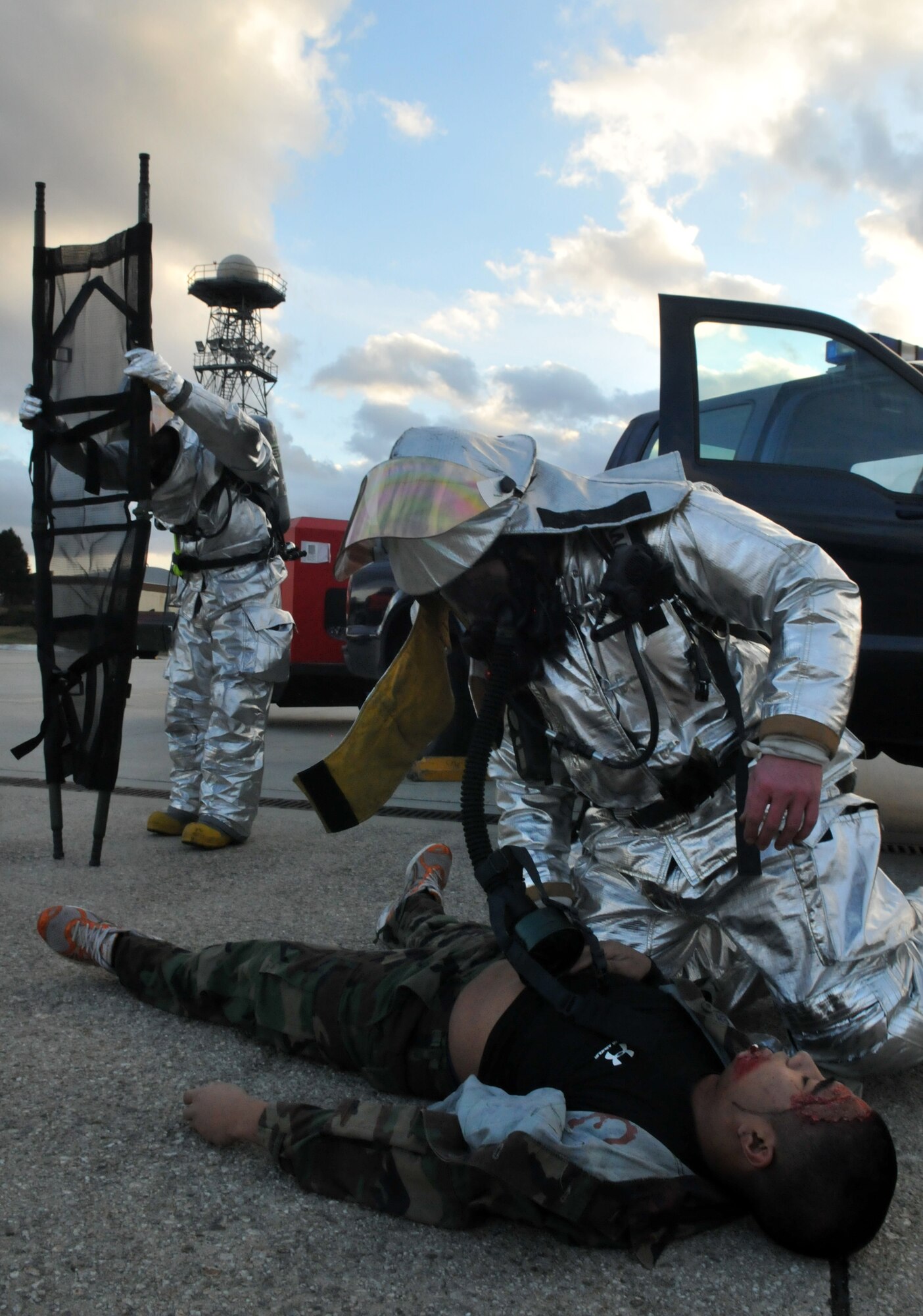 SPANGDAHLEM AIR BASE, Germany – 52nd Civil Engineer Squadron firefighters prepare a stretcher while providing self-aid and buddy care to Airman 1st Class Urzus Gange, 52nd Logistics Readiness Squadron mobility journeyman, after a simulated car accident during Operation Saber Crown 10-04 here March 1. Members of the 52nd Fighter Wing participated in the Phase II exercise to evaluate the wing’s ability to survive and operate in a chemical, biological, radiological, nuclear and explosive environment. (U.S. Air Force photo/Airman 1st Class Nick Wilson)