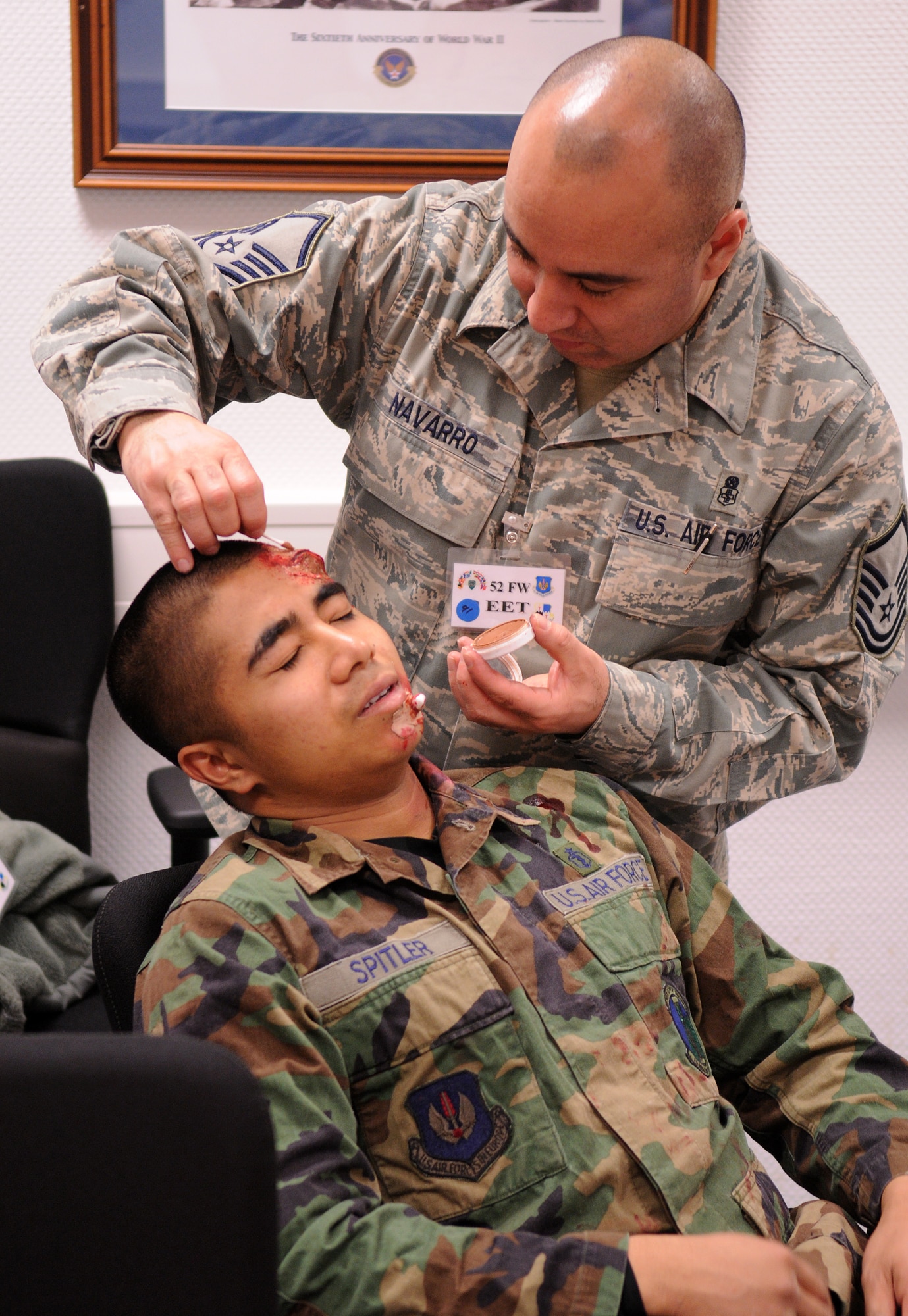 SPANGDAHLEM AIR BASE, Germany – Master Sgt. Apolinar Navarro, 52nd Medical Group, applies artificial blood to moulage victim Airman Urzus Gange, 52nd Logistics Readiness Squadron, during Operation Saber Crown 10-04 here March 1. Moulage, the art of applying mock injuries for training, is used to help assess self-aid and buddy care knowledge for Airmen during exercises. (U.S. Air Force photo/Senior Airman Nathanael Callon)